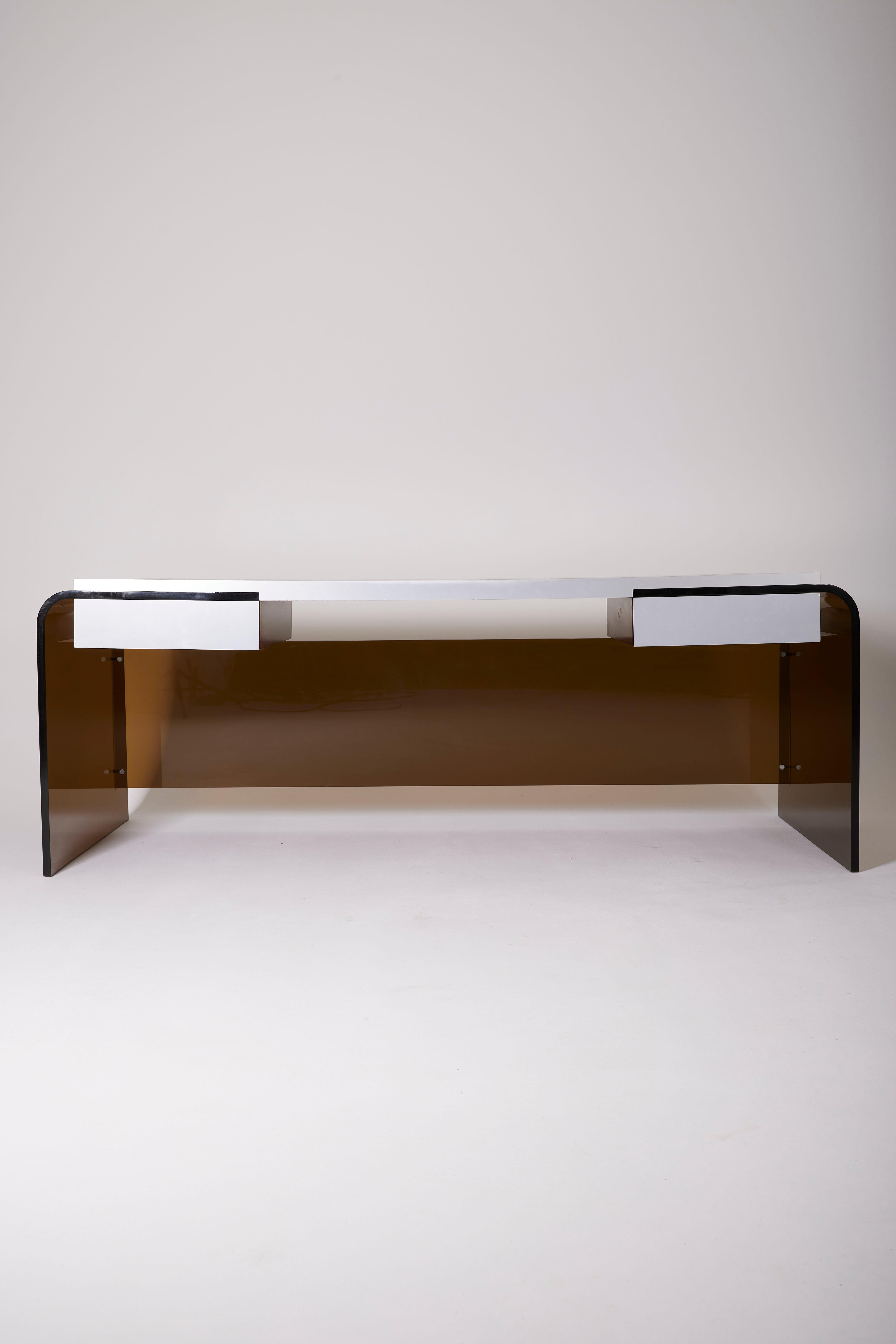 Large desk in Altuglas and ebony in the style of Joseph André Mott from the 1970s. The top is made of Macassar ebony with brushed steel details, and the base is in smoked plexiglass. The desk is equipped with 2 drawers beneath the top. In good