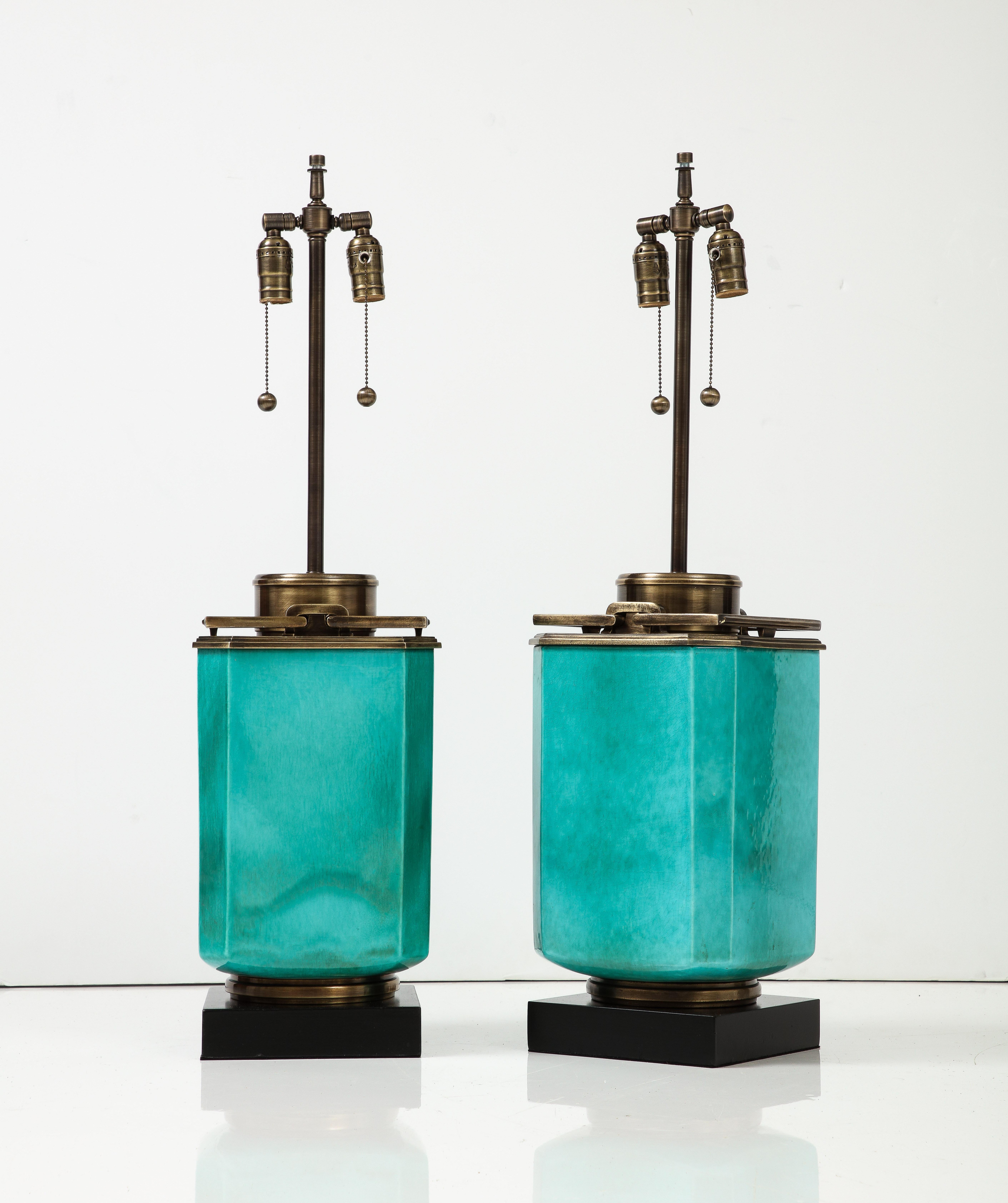 Impressive large scale Jade green porcelain lantern lamps featuring aged brass hardware. Lamps have been rewired for use in USA using edison type bulbs, 75W max bulbs. Lamps sit upon black enameled square wood bases.