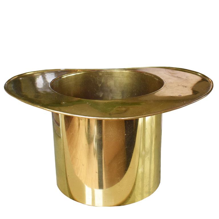 A life-size brass tophat ice, wine, or champagne bucket. This shiny gold piece will be a great accent for your next dinner or cocktail party. This piece is by Bates of Birmingham and is created from brass. Fill it with ice, a smidge of water, and
