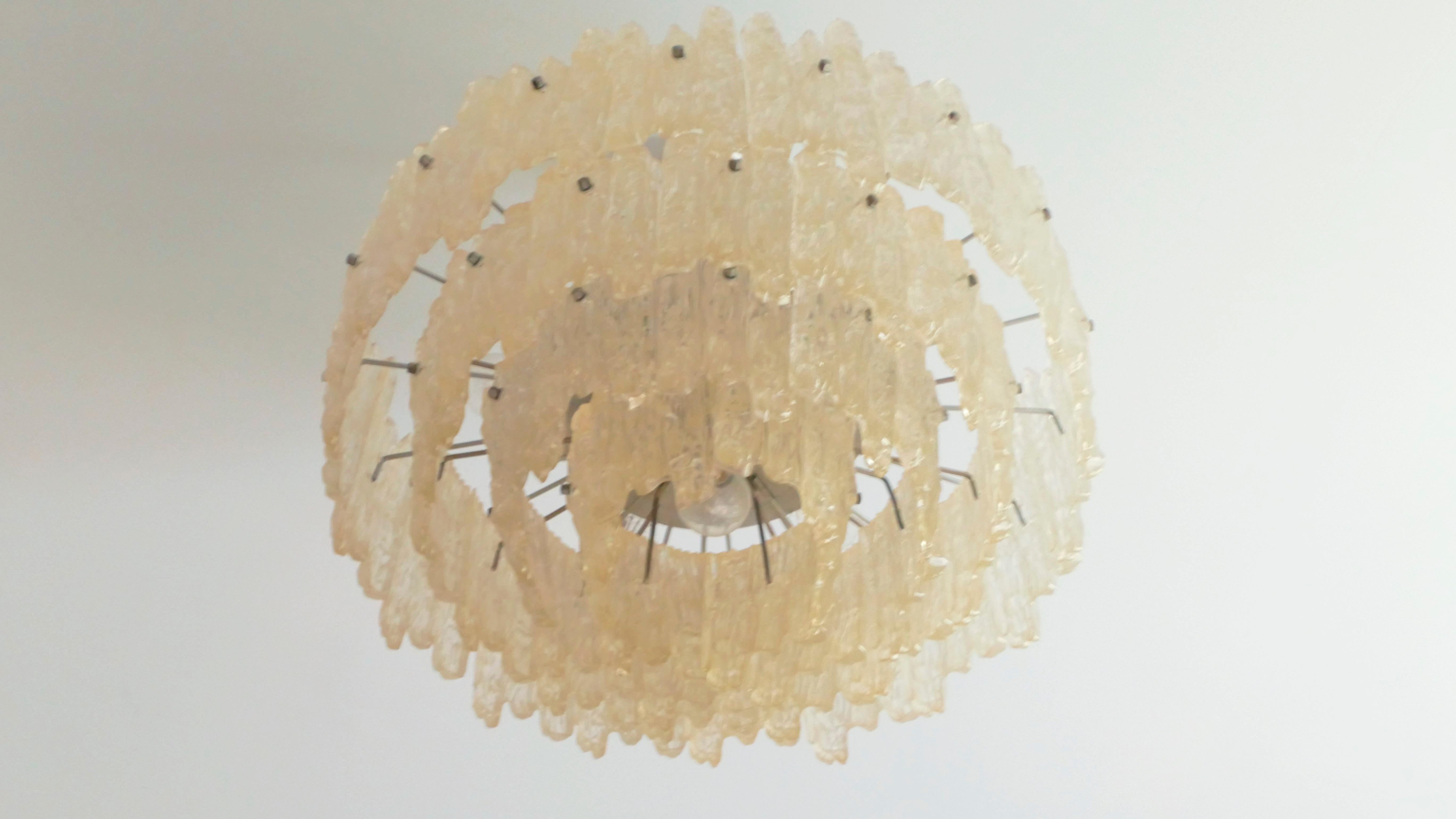 An immediately arresting piece, this vintage Kinkeldey chandelier is crafted from brushed metal and Lucite, formed to resemble haunting melting icicles. Its warm, yellow light is refracted through the icicles that feels cozy and imaginative. This