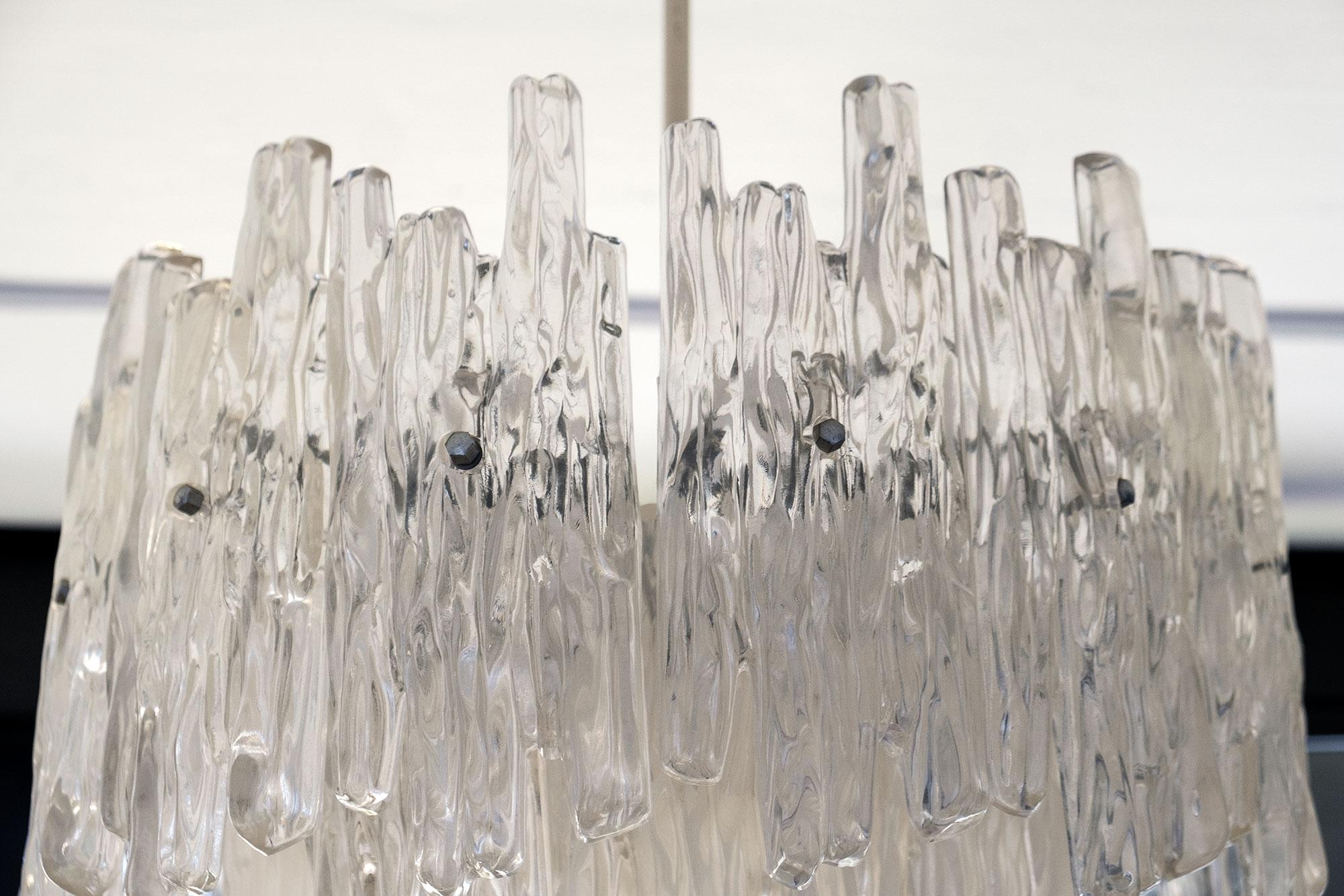 This stunning chandelier by Kinkeldey is crafted from brushed metal and lucite, formed to resemble haunting melting icicles. 
It gives a beautiful warm light an eye-catcher.