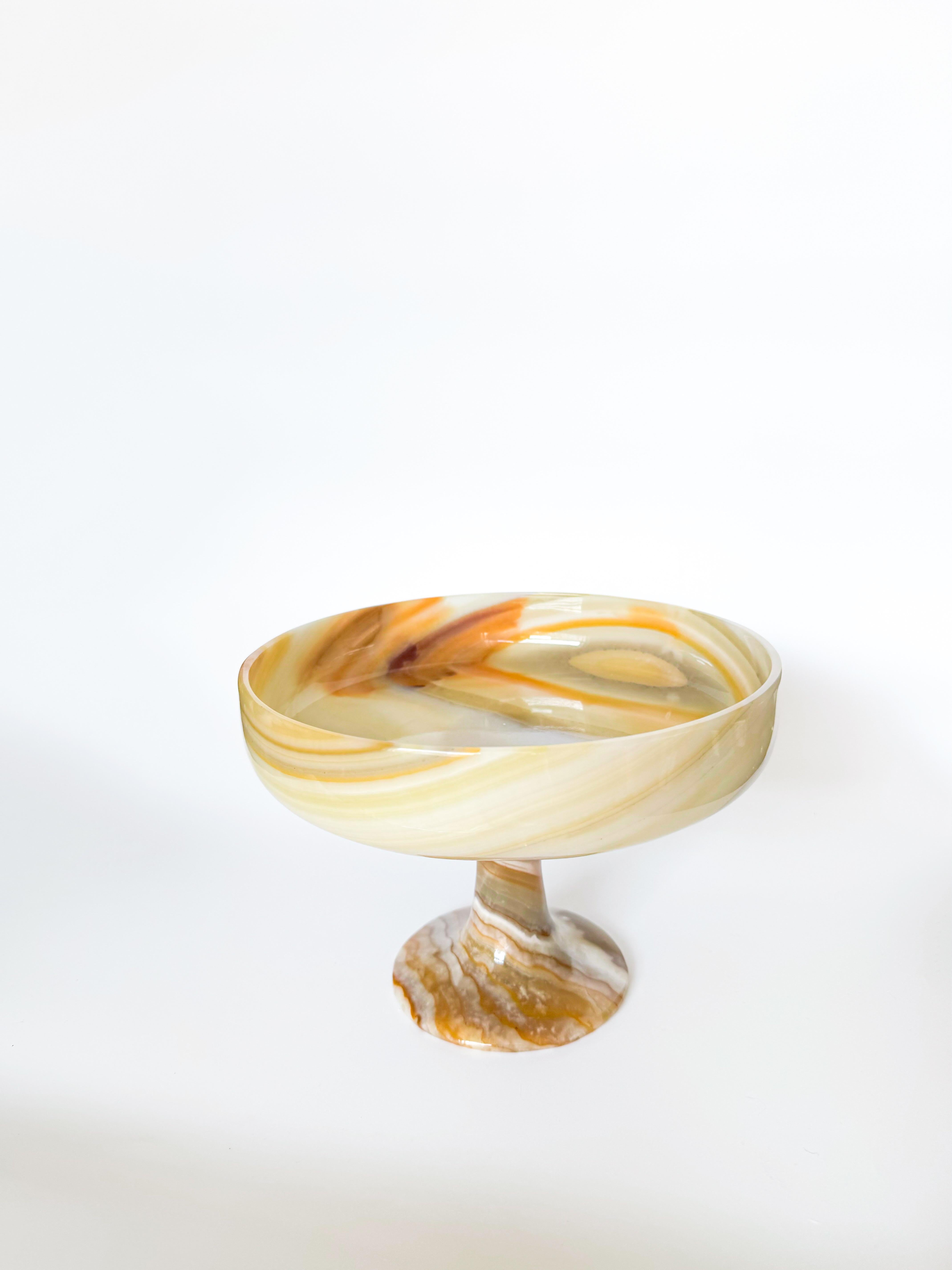 Embrace the organic modern aesthetic with this vintage onyx stone bowl, a stunning piece with deep Italian roots. Made in the 1970s, this substantial bowl is both large and heavy, showcasing the luxurious qualities of genuine onyx stone. With warm,