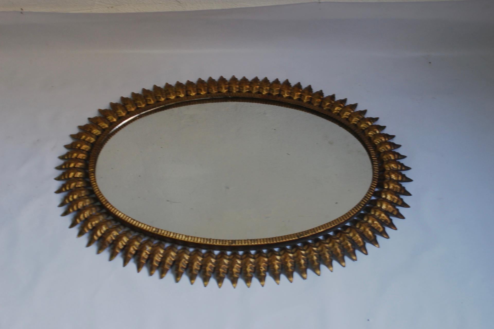 Midcentury large oval sunburst or floral mirror, made in Spain during the 1950s.