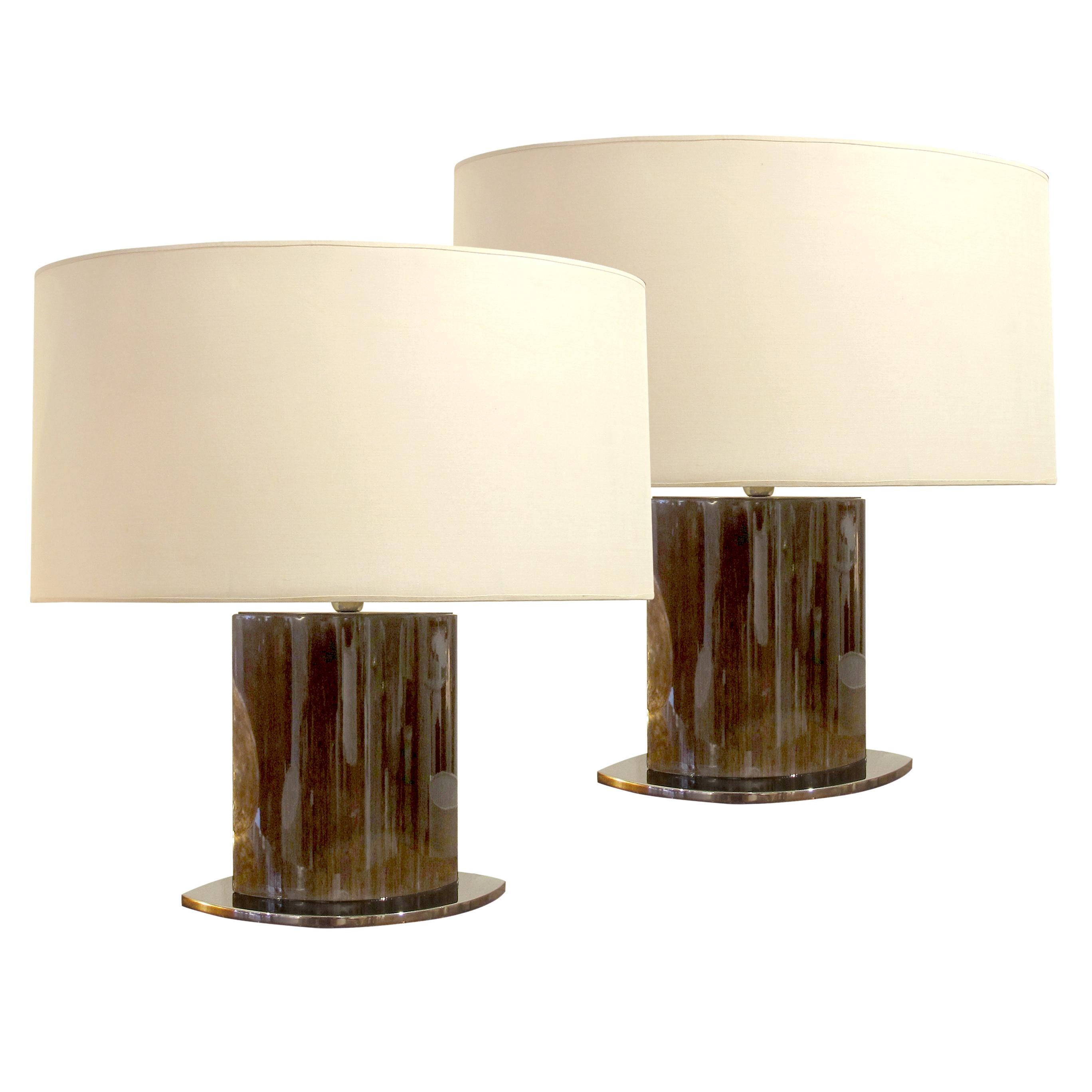 These elegant pair of Italian table lamps from the 1950s exemplify the sleek, modernist aesthetic of the mid-century design. Each table lamp features a polished chrome base, and its clean, minimalist lines contrast the warmth of lacquered rosewood.