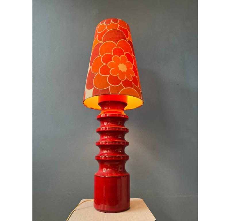 Large red ceramic table lamp with newly made, orange flower shade. The fat lava style base has a thick red lacquer. The orange shade produces a warm, cosy glow. The lamp requires one E27/26 lightbulb and currently has an EU-plug.

Additional
