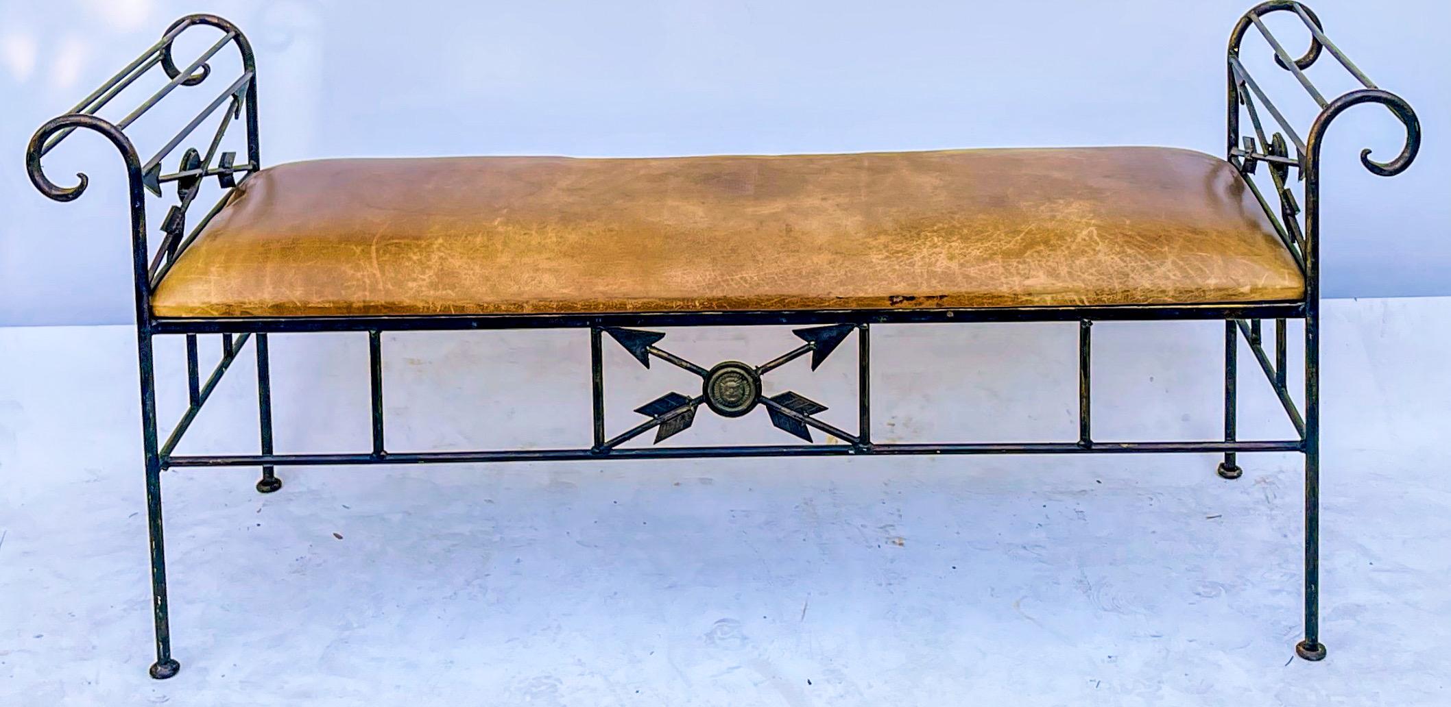 This is a mid-century large scale neo-classical style Italian iron and leather bench. It has a distressed saddle colored leather, and the iron frame is in very good condition. It is unmarked.