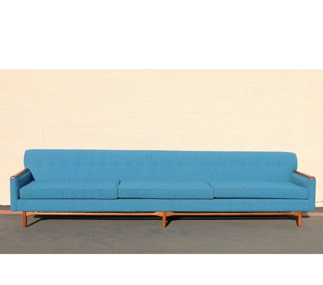 Wonderful Mid-Century three seats sofa from the 1960s. This sofa is in excellent condition. It has been restored, (refinished and reupholstered). The fabric it is absolutely clean and the base of the sofa it is made of walnut wood. The buttons are