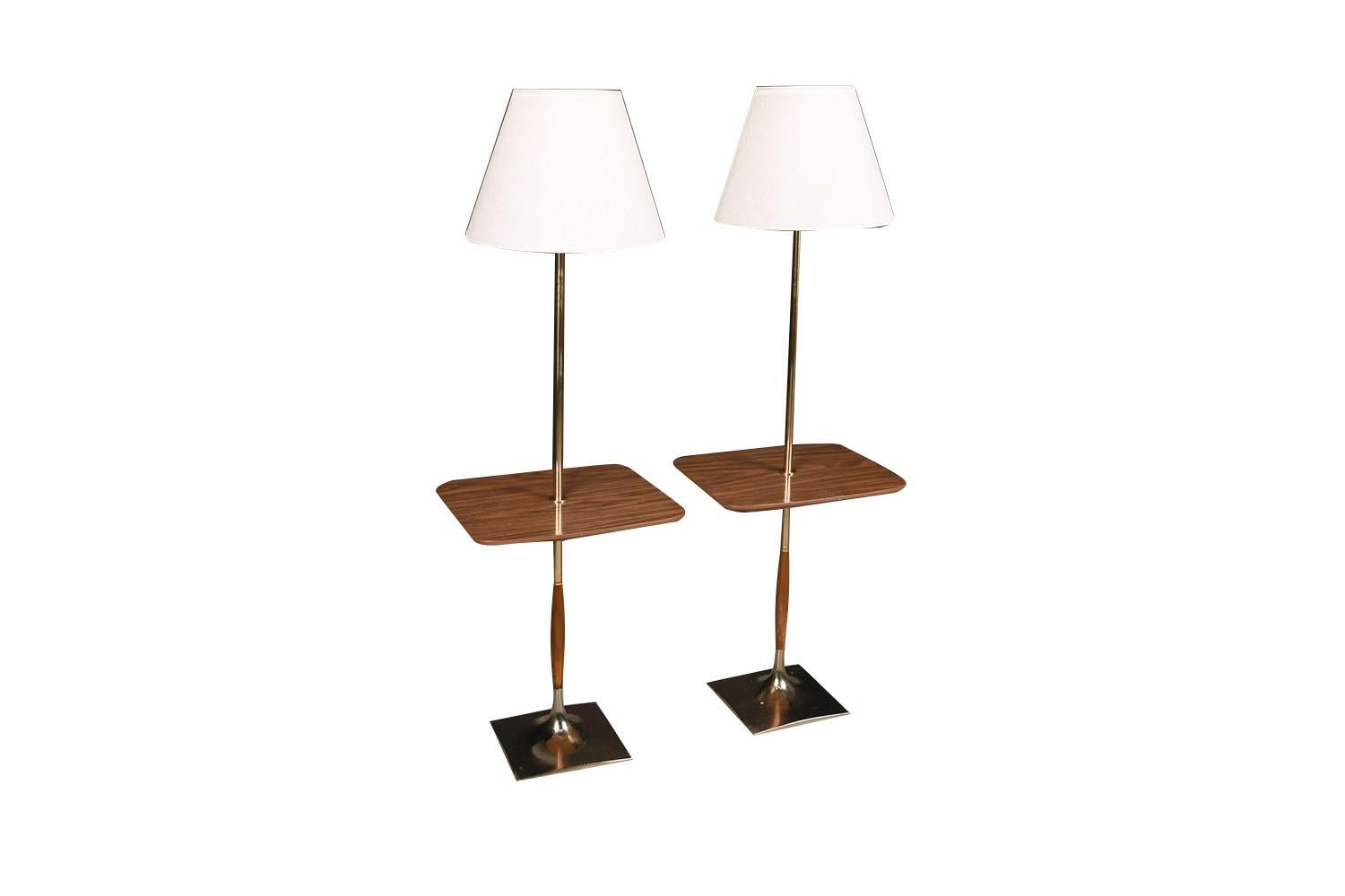 Magnificent pair of Mid-Century Modern walnut and brass table floor lamps circa 1960s, by Laurel Lamp Mfg Co, MCM exquisite craftsmanship features glass diffusers and white shades. They each have central built-in waterproof rectangular wood grain