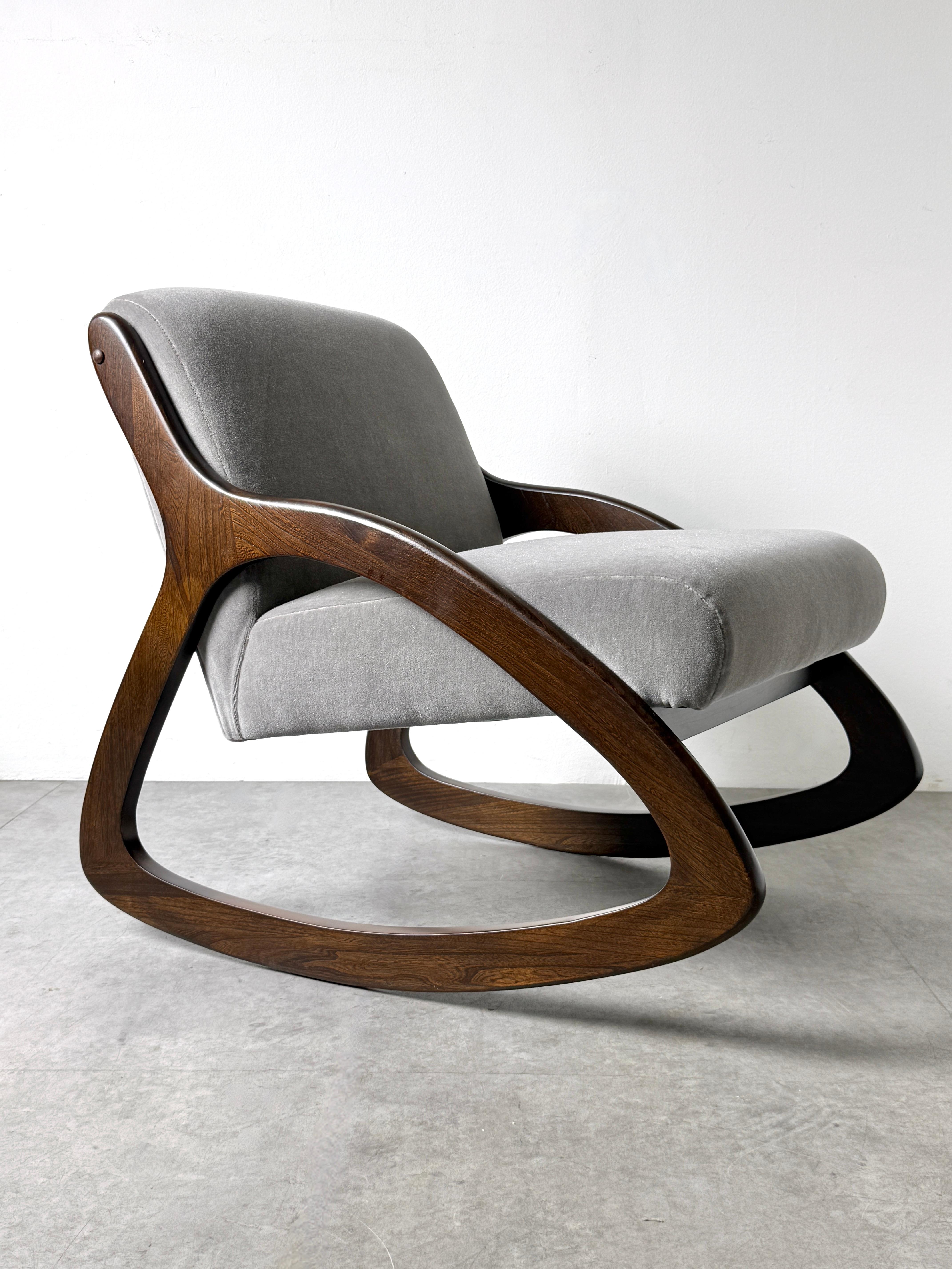 A rare contoured rocking chair designed by Lawrence Peabody for Richardson Nemschoff circa 1960s

Freeform design with continuous sculpted wood frame in dark finish supporting a floating seat in silvery gray mohair

Professionally restored with new