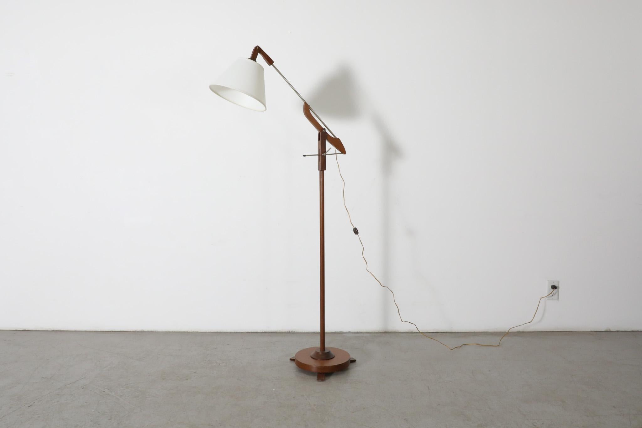 Mid-Century or earlier teak cantilevered floor lamp, likely by Le Klint, Povl Dinesen, Hans Bergström or one of their contemporaries. The light's head articulates and can be positioned at various angles. The unique lever mechanism can be used to