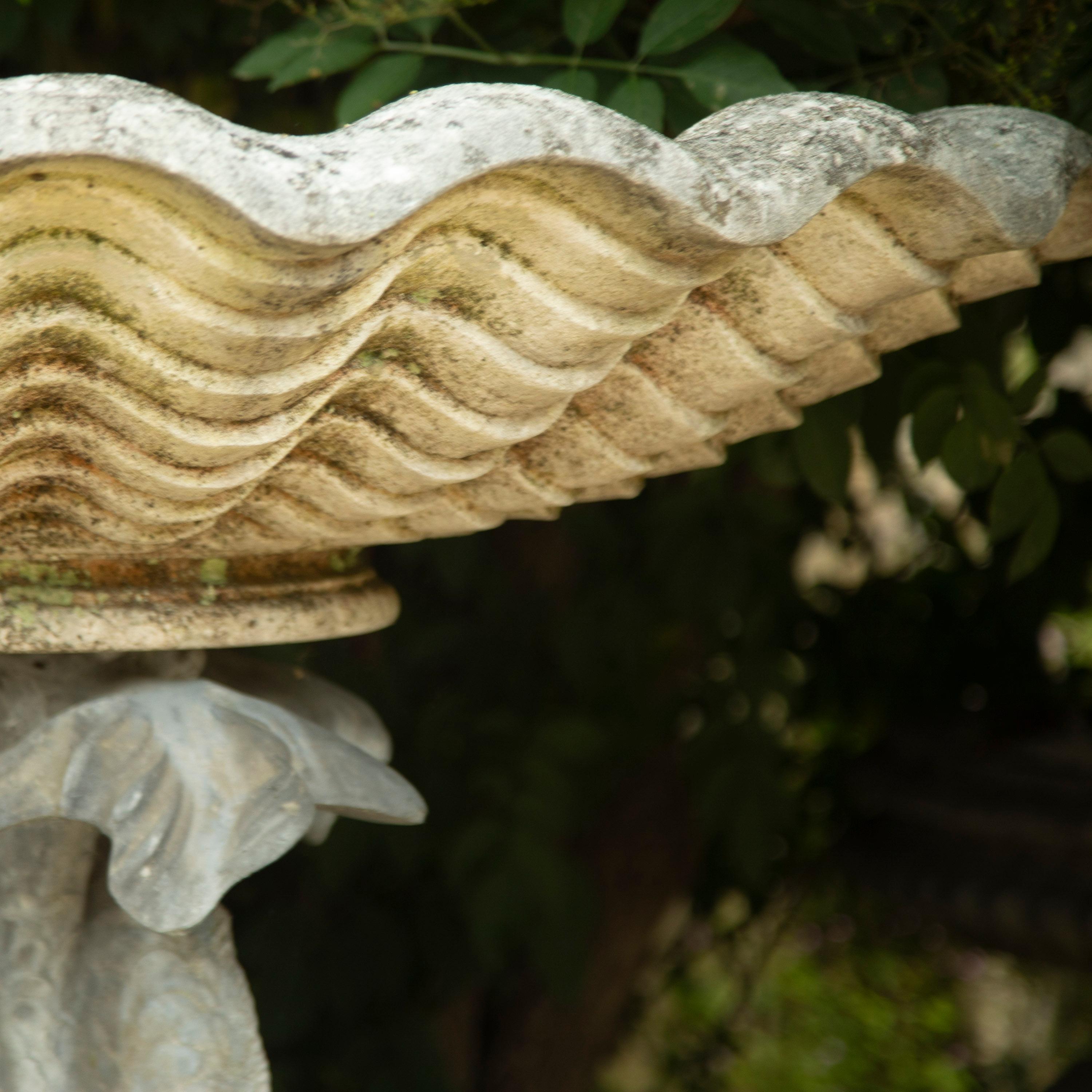 Wonderful English Mid Century water feature, circa 1950. 

This beautiful piece comprises a fountain in the form of a trio of stylised lead dolphins. The dolphins support a large carved stone scalloped shell bowl. 

Resting on a shaped stone