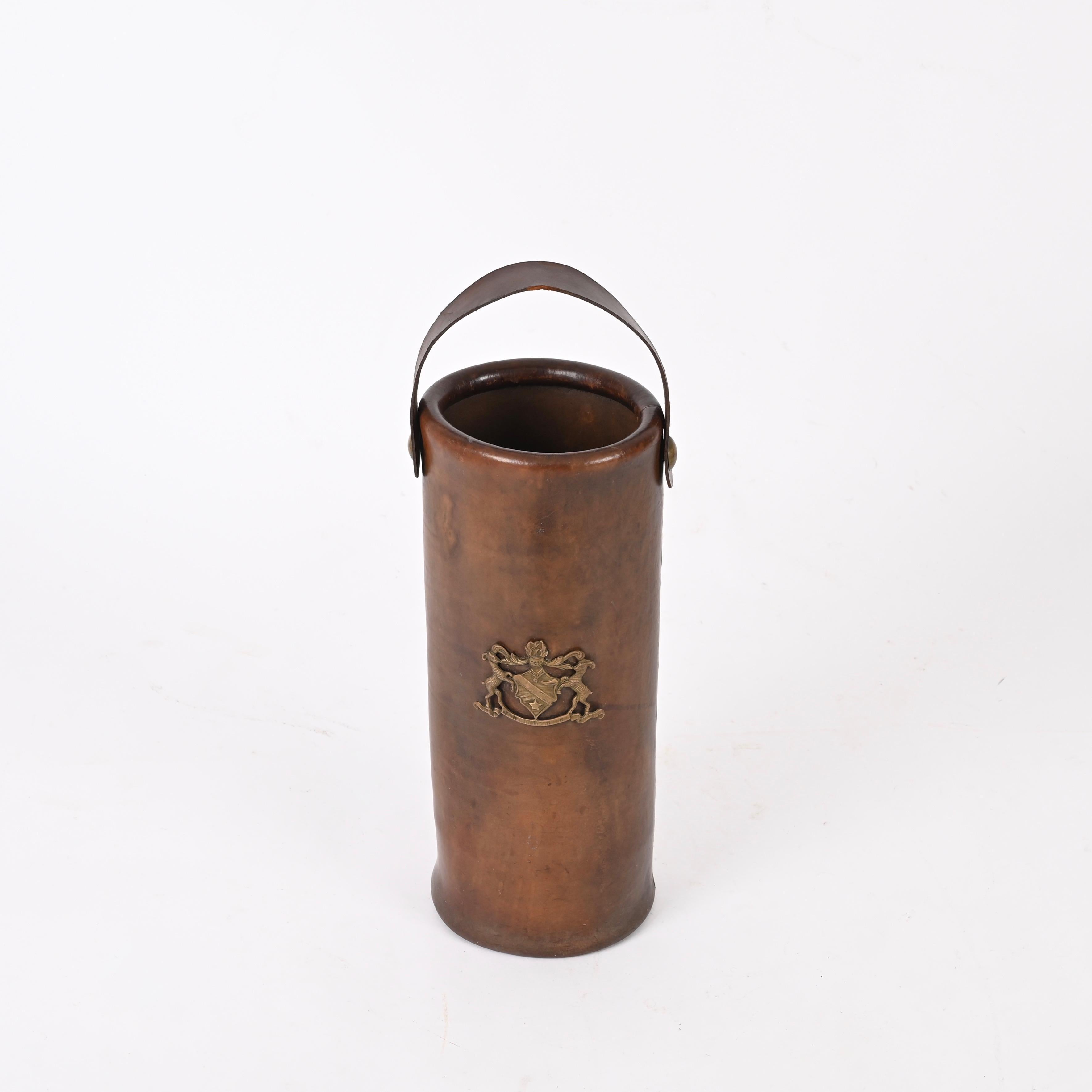 Beautiful Mid-Century umbrella or walking stick stand fully made in thick leather and enirched with a brass emblem in the middle.

This charming round umbrella stand is fully made in a fantastic thick leather that has built a gorgeous even patina.