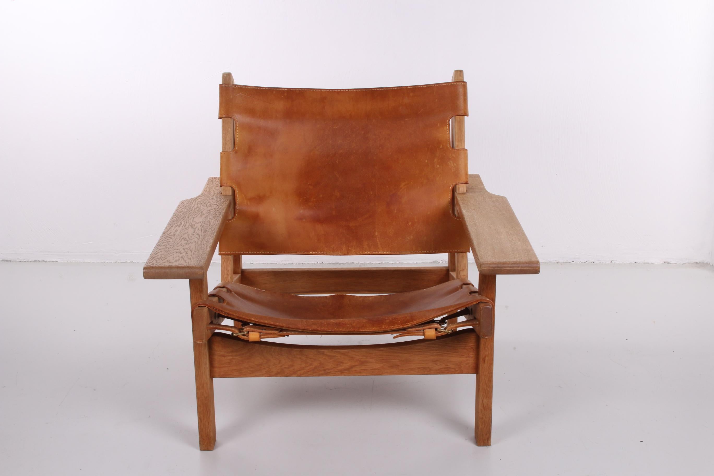 This beautiful Safari chair has a solid oak wood frame. It was made by the Danish designer Kurt Østervig for KP Møbler. The saddle leather seat has a rich cognac color and is attached tot the chair with several clasps and buckles that show on the