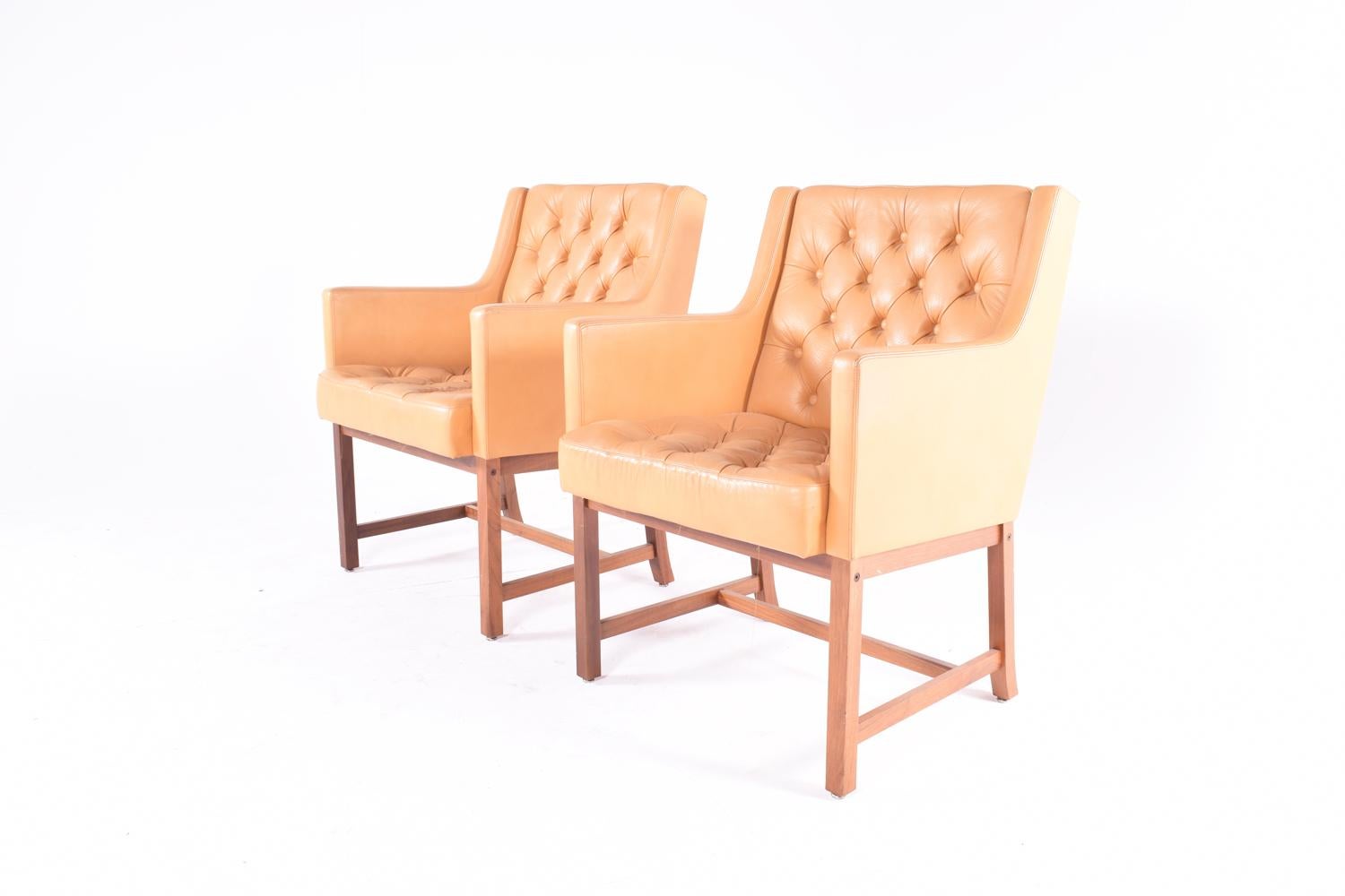 Great example of a pair of camel tufted leather chairs with solid teak legs, designed by Karl Erik Ekselius for JOC Mobler, Sweden. Original leather in very good condition with no tears or damage, and shows a minor amount of nice patina.