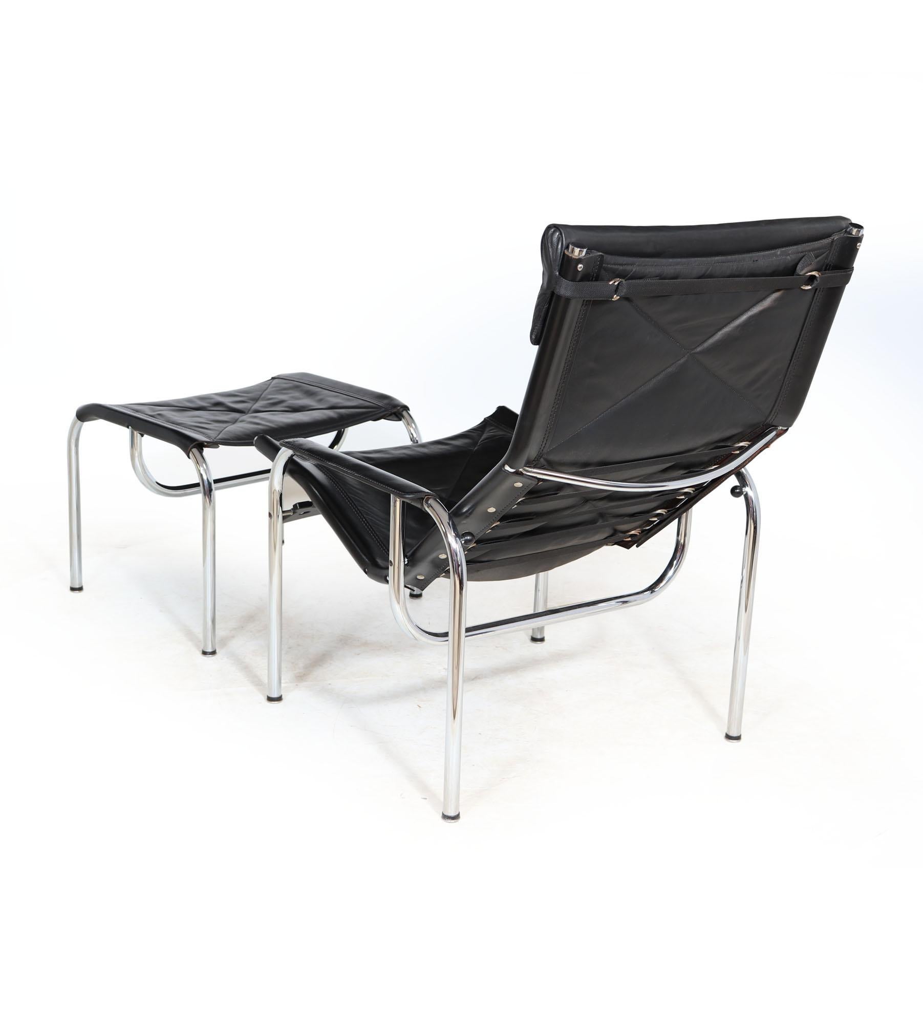 An Armchair and foot stool set designed by Hans Eichenberger and produced by Swiss company Strassel, the chair reclines and fixes into reclined position, with tubular chromed steel frame and thick leather upholstery the chair is in excellent