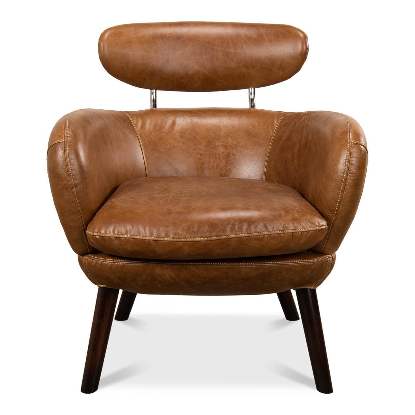 Mid-Century Modern style leather upholstered armchair with a floating headrest, with vintage style aniline top grade brown leather with a tub back form, cushion seat and raised on splayed legs.

Dimensions: 28