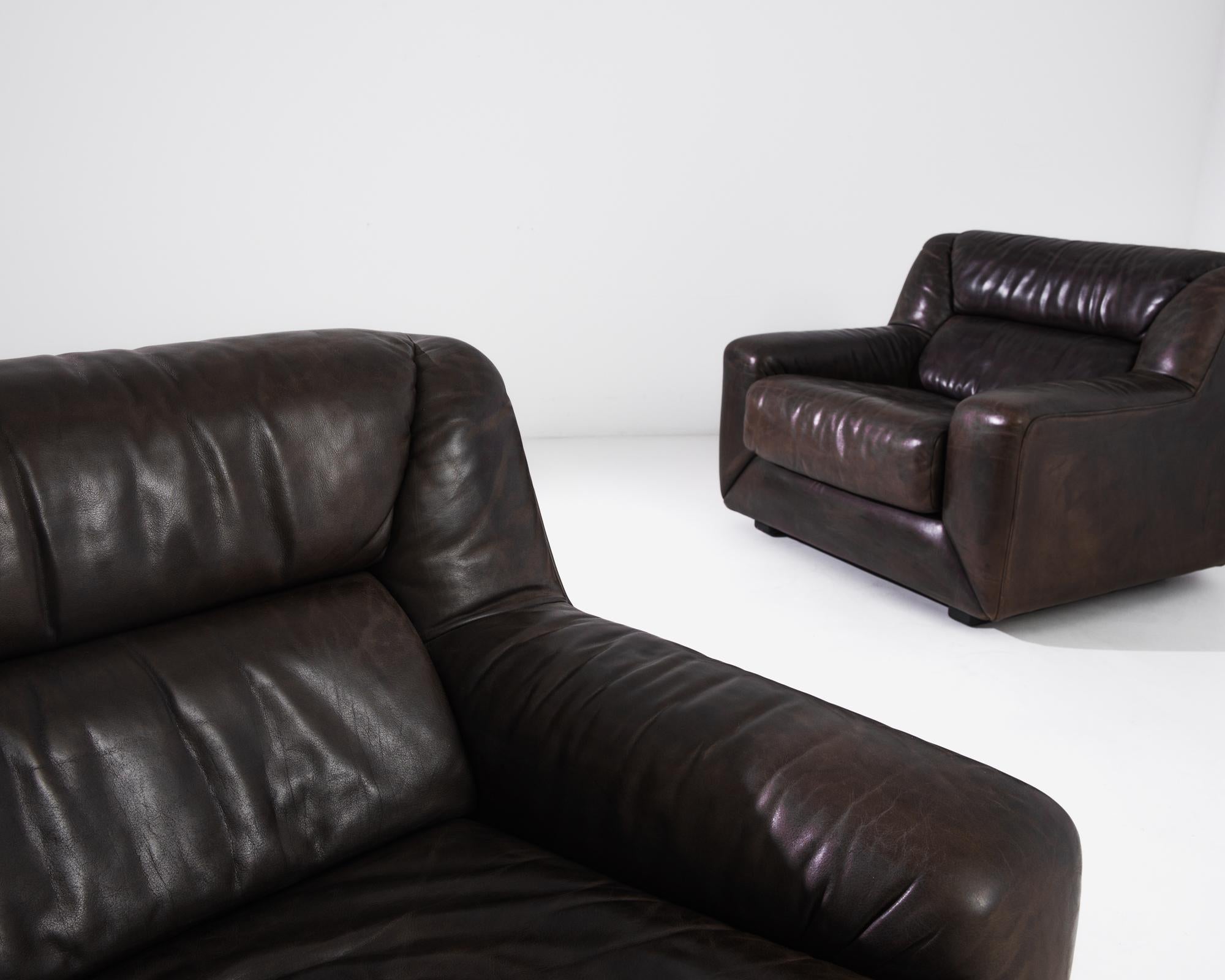 A pair of upholstered leather armchairs made circa 1970 by the iconic company De Sede, a Swiss manufacturer of exclusive furniture. These low and wide lounge chairs lay full focus on comfort and authentic design. The cubic structure gives them an