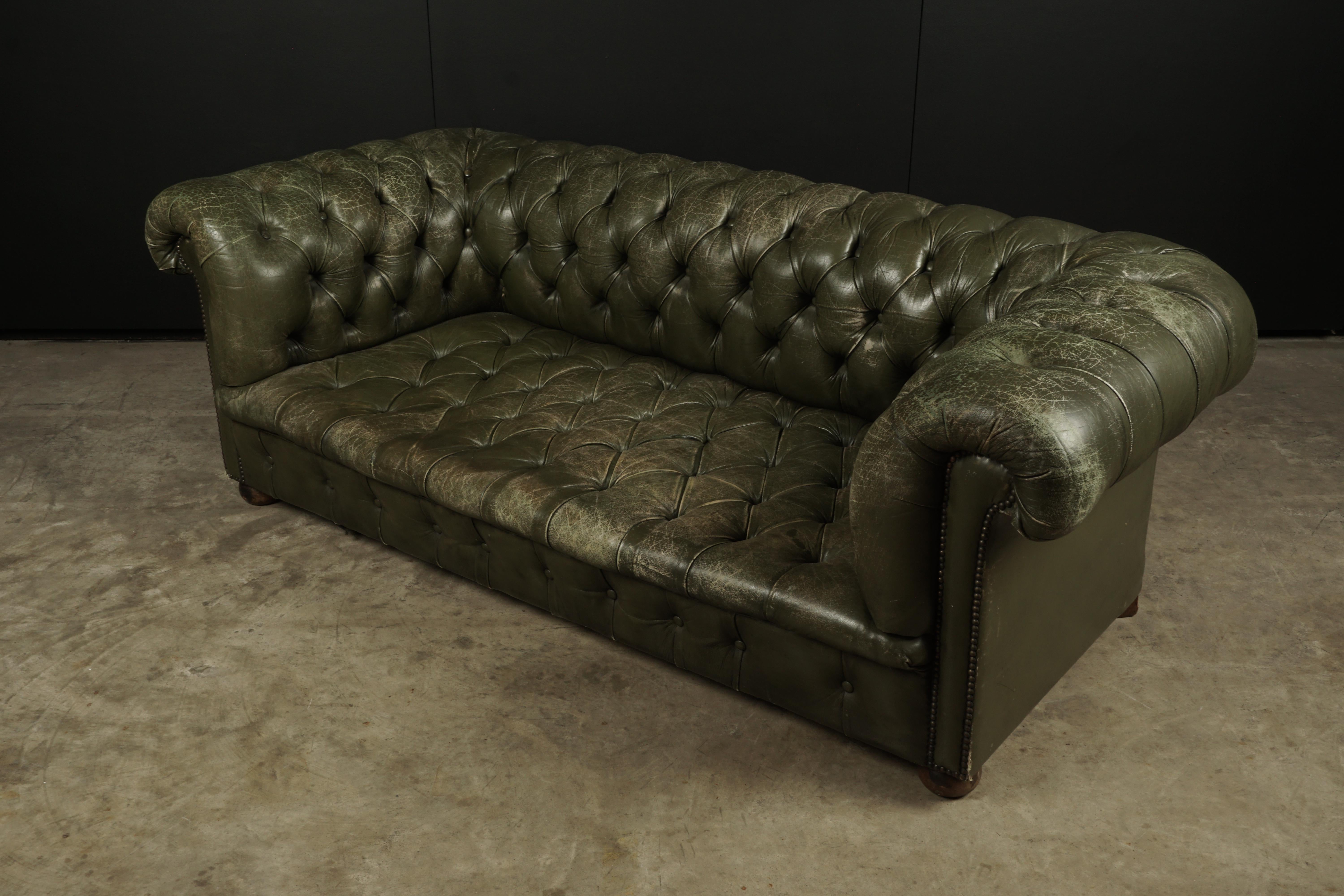 Vintage leather Chesterfield sofa from England, circa 1960. Original green leather upholstery with fantastic patina and wear.