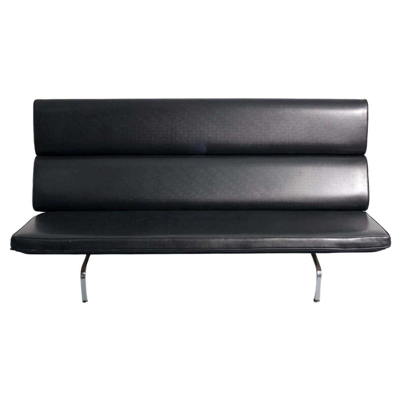 Original Eames-Sofa kompakt mit originaler schwarzer Lederpolsterung. Die kompakte Couch von Charles und Ray Eames ist ein großartiges Design, das ein subtiles Profil behält. Die gepolsterten Pads, die die Rückenlehne bilden, sind mit einer