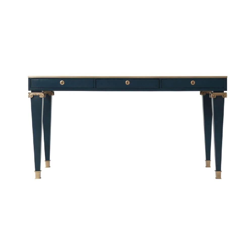 A midcentury style cobalt blue leather-wrapped writing table, the rectangular brass bound top above three lockable frieze drawers with brass escutcheons, on brass column capital cobalt blue painted square tapering legs with brass feet.

This is an
