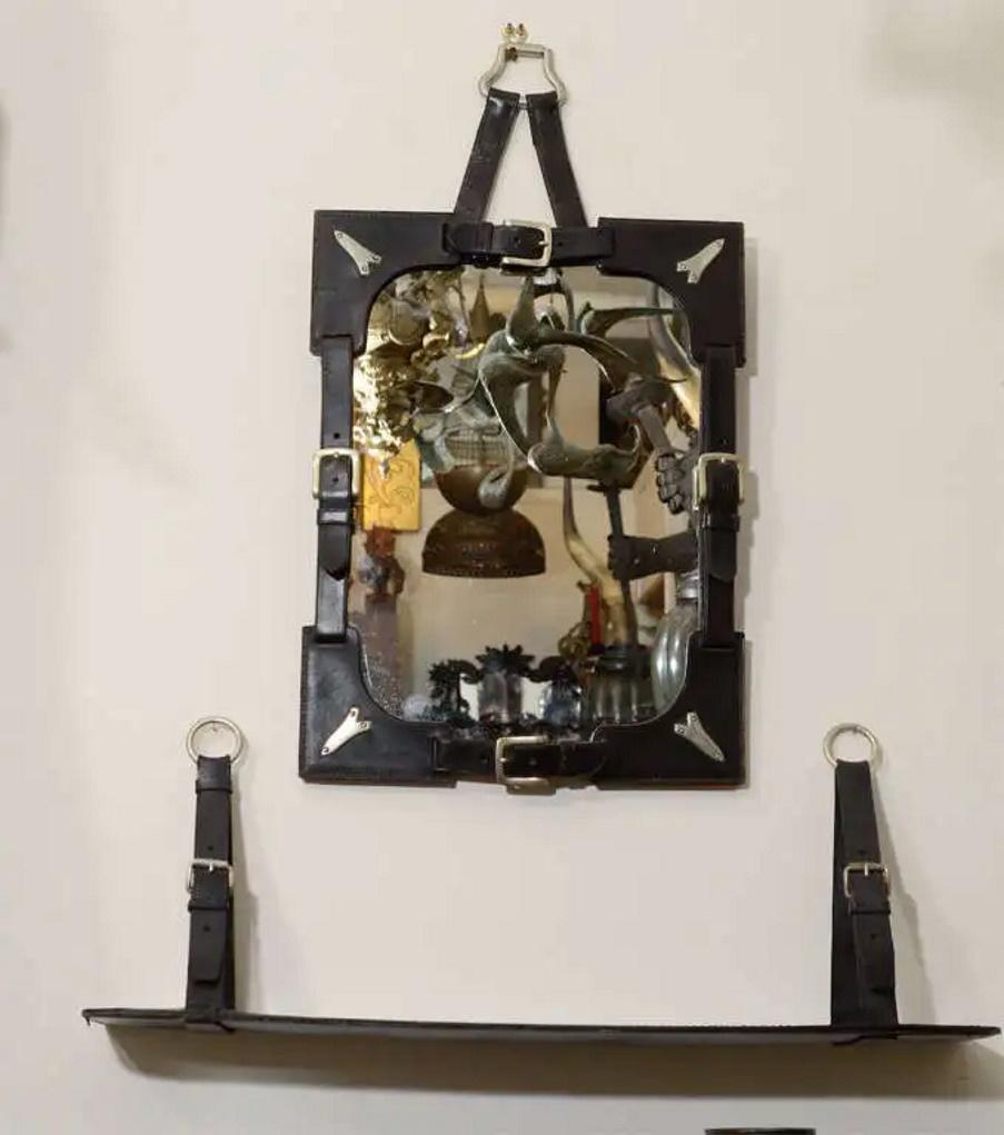 Modernismo de mediados de siglo
al estilo de 
Jacques Adnet 
Espejo con marco de cuero y estante 
Alrededor de 1970
DIMENSIONES
Dimensiones Espejo: 27