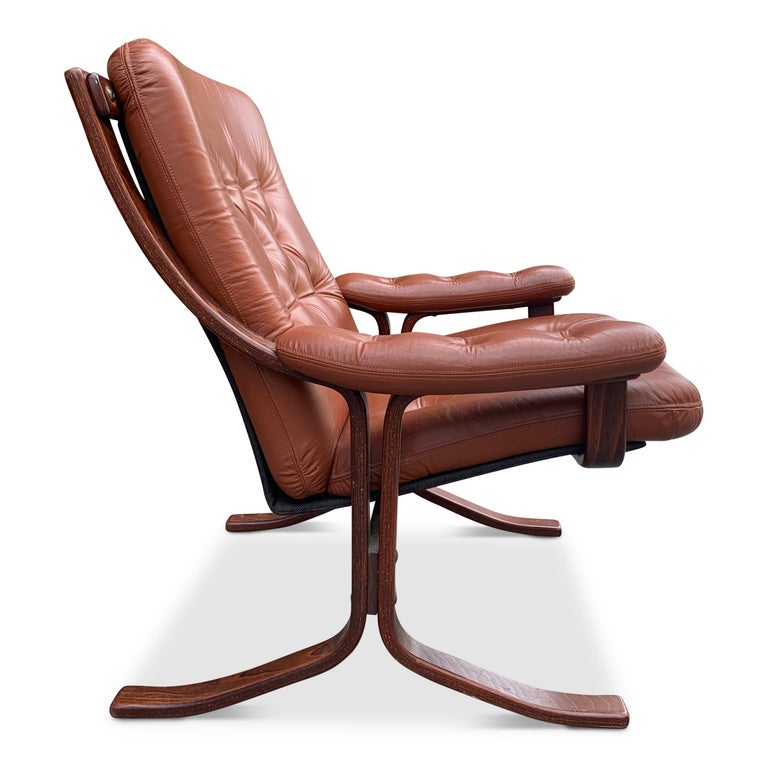 A dapper midcentury lounge armchair with warm and inviting soft leather. Most comfortable chair with paired with an ottoman, will become a family favorite.