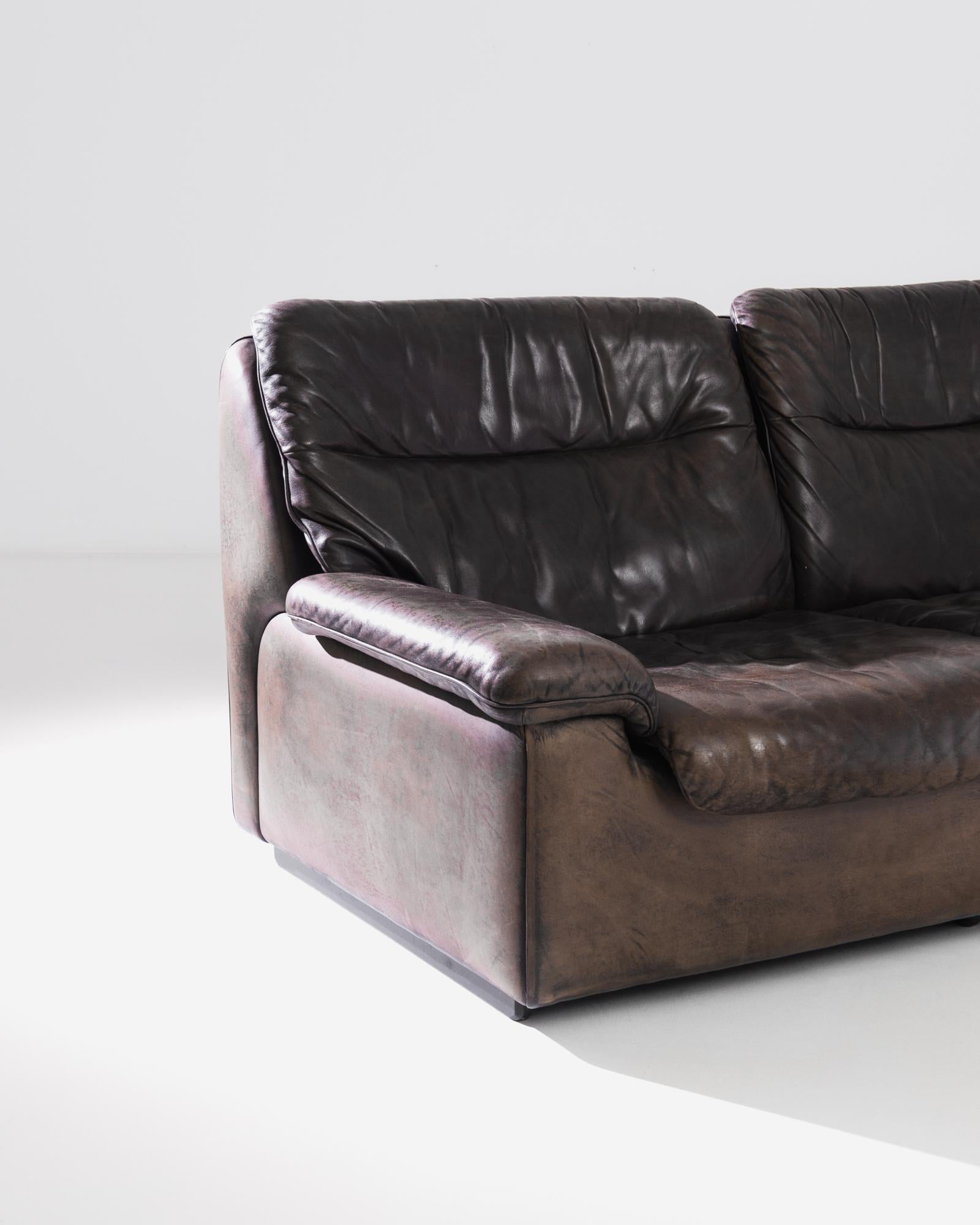 An upholstered leather loveseat made circa 1970 by the iconic company De Sede, a Swiss manufacturer of exclusive furniture. This low and wide loveseat lays full focus on comfort and authentic design. The cubic structure gives an original outline,