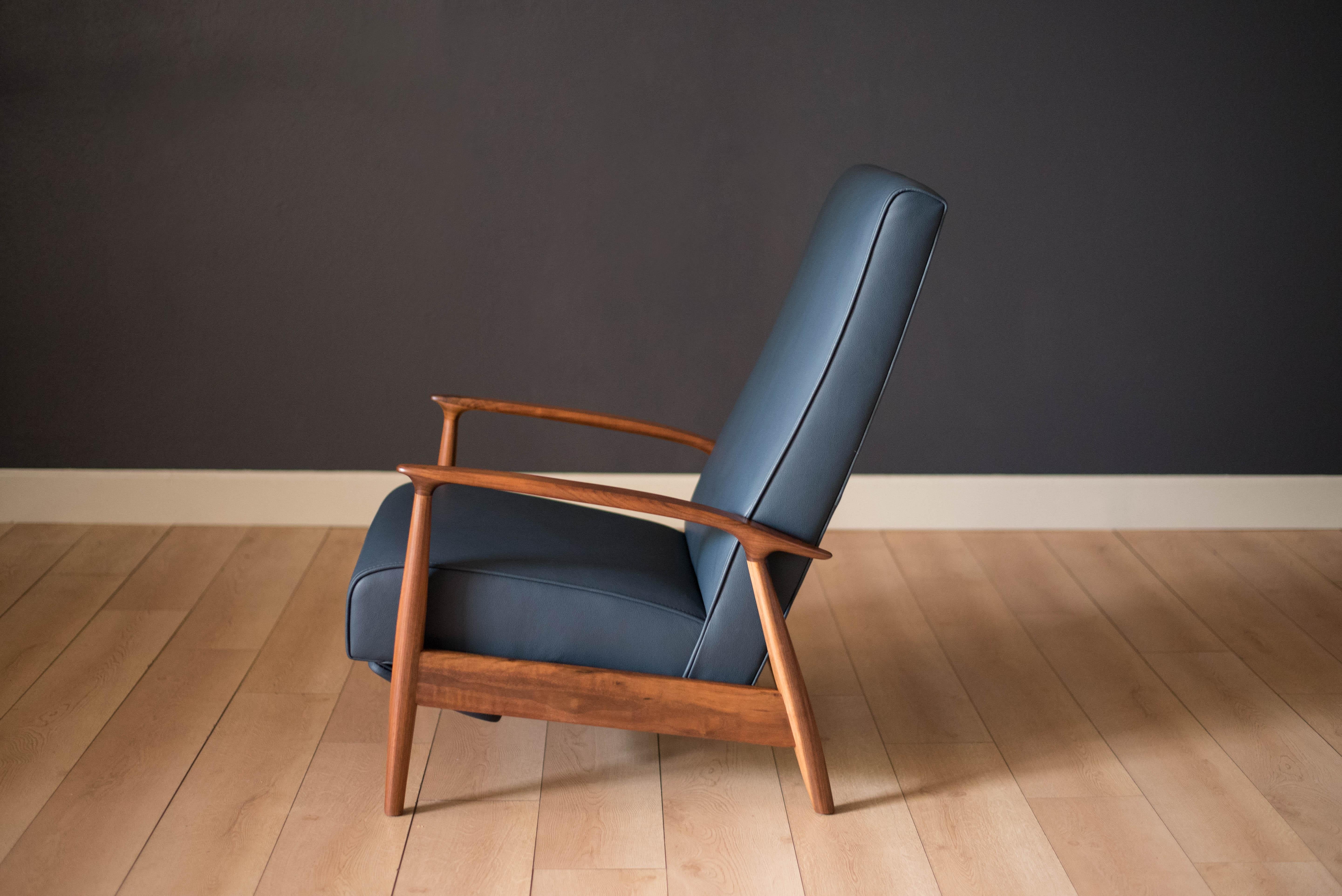 Mid-Century Modern reclining lounge chair designed by Milo Baughman for James. Inc. This piece has a sculptural walnut frame and is reupholstered in blue leather. Reclining mechanism adjusts to three different positions.


 