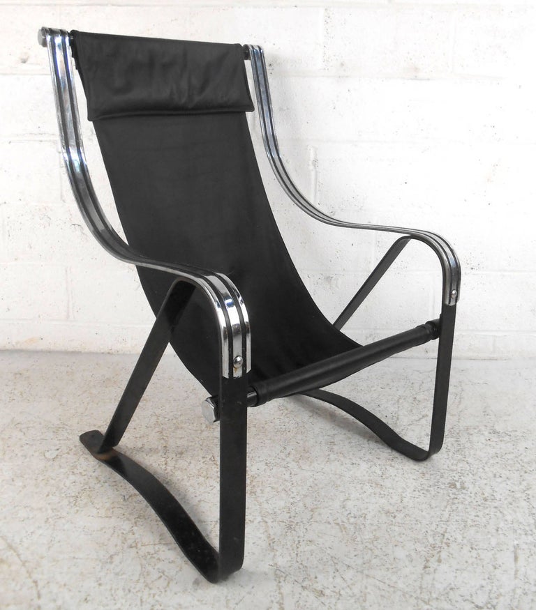 This stylish chair combines leather, iron, and chrome to create a comfortable midcentury seating option for any room. Unique head rest, decorative chrome, and cantilevered base make this a wonderful addition to any room. Please confirm item location