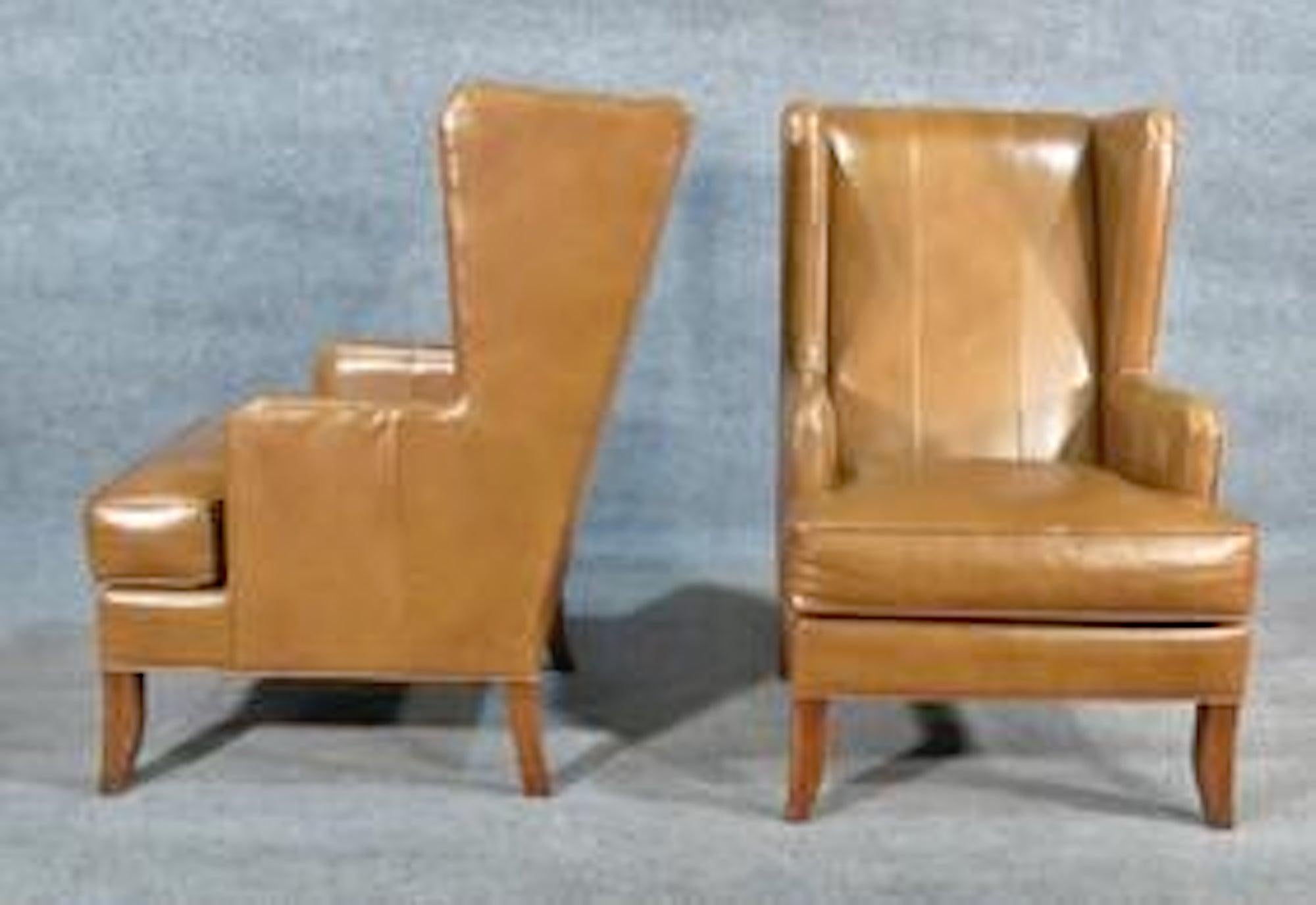 Pair of handsome leather wing chairs with wood feet.
(Please confirm item location - NY or NJ - with dealer).
  
