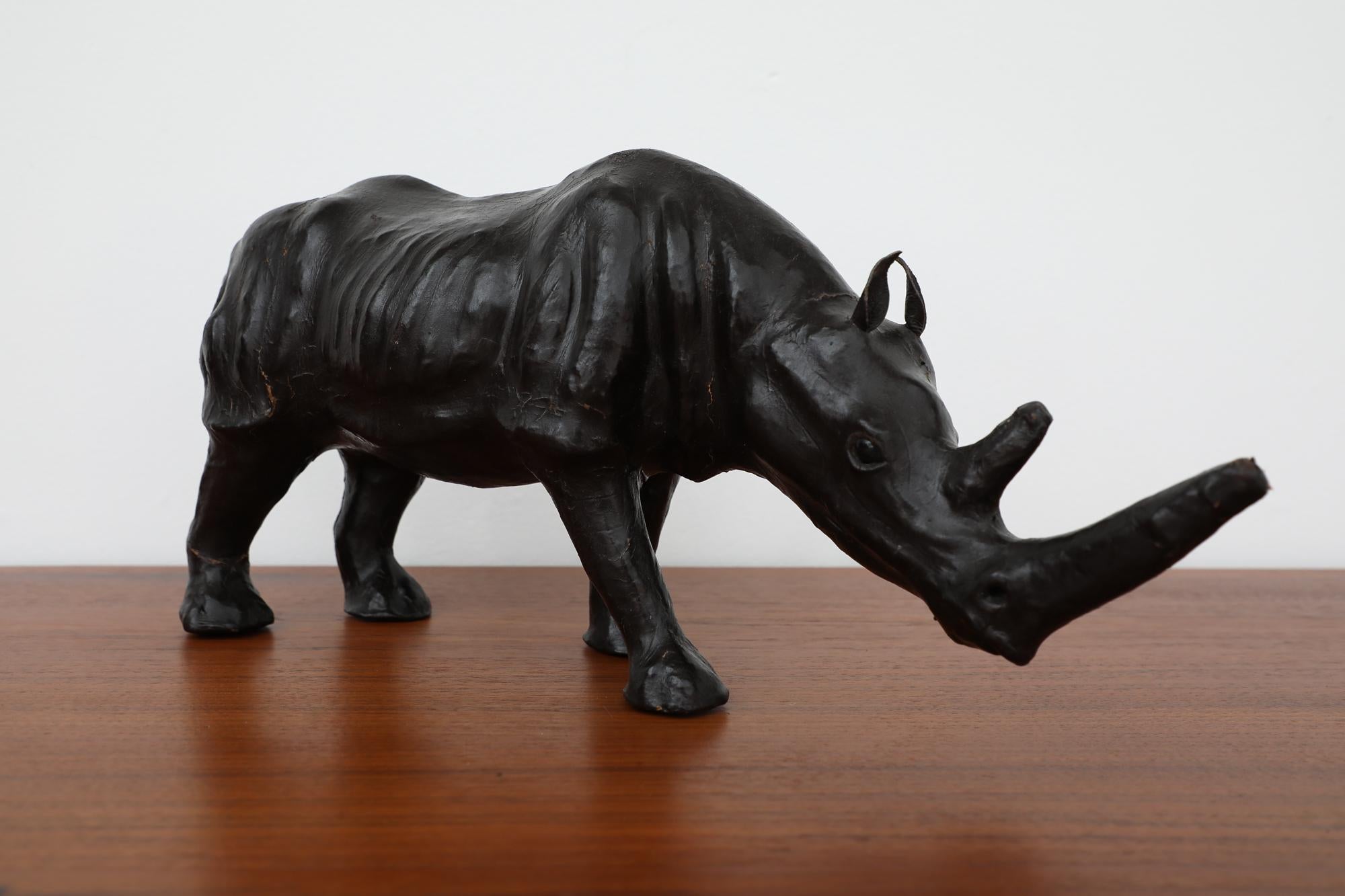 Mid-Century leather wrapped rhinoceros statue. In original condition with visible wear consistent with its age and use.
