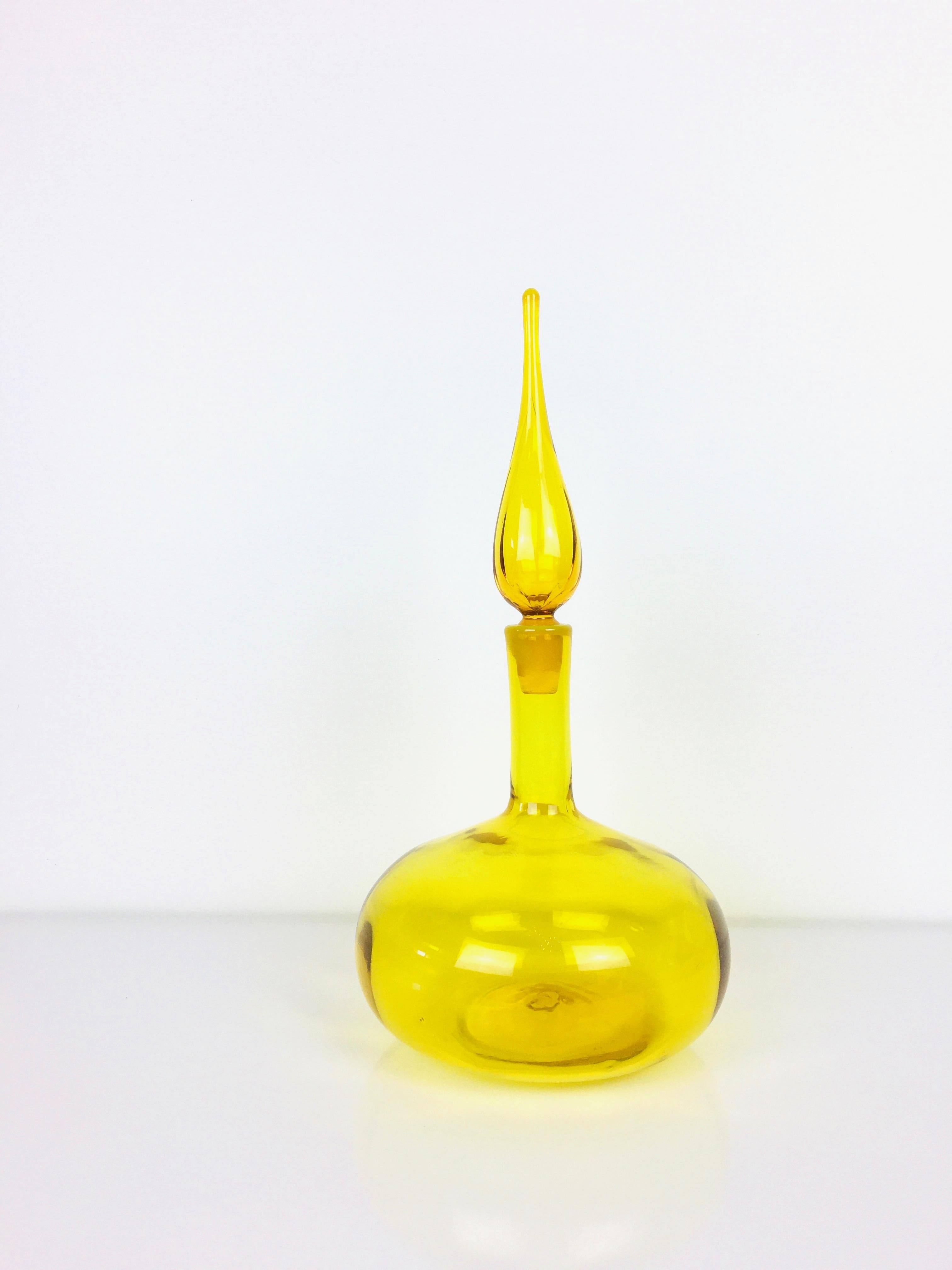 Mid-century lemon yellow glass genie bottle / decanter.
Color is bright & vivid.
Tall stopper at top.
Blown glass, pontil mark at bottom.
Excellent condition.