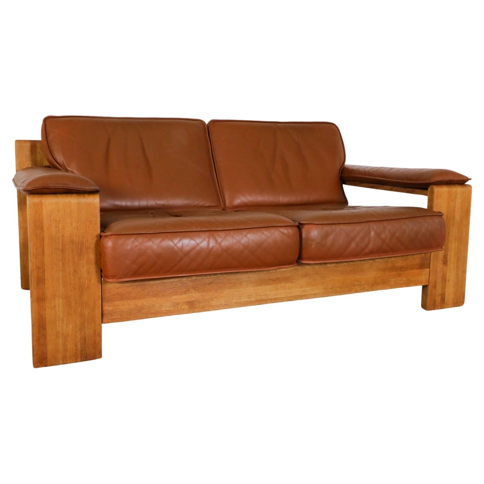 Mid-Century Leolux light oak loveseat with removable headrests. Beautiful natural Cognac leather cushions with light patina and 'Leolux' printed canvas support sling. The removable leather headrests seamlessly slot into the sling support for