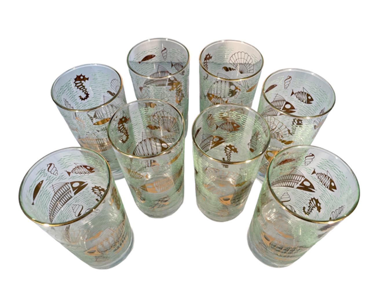 Set of eight Libbey Glass highball glasses in the Marine Life pattern decorated with 22 karat gold atomic style fish and other marine life within raised translucent green 'waves'.