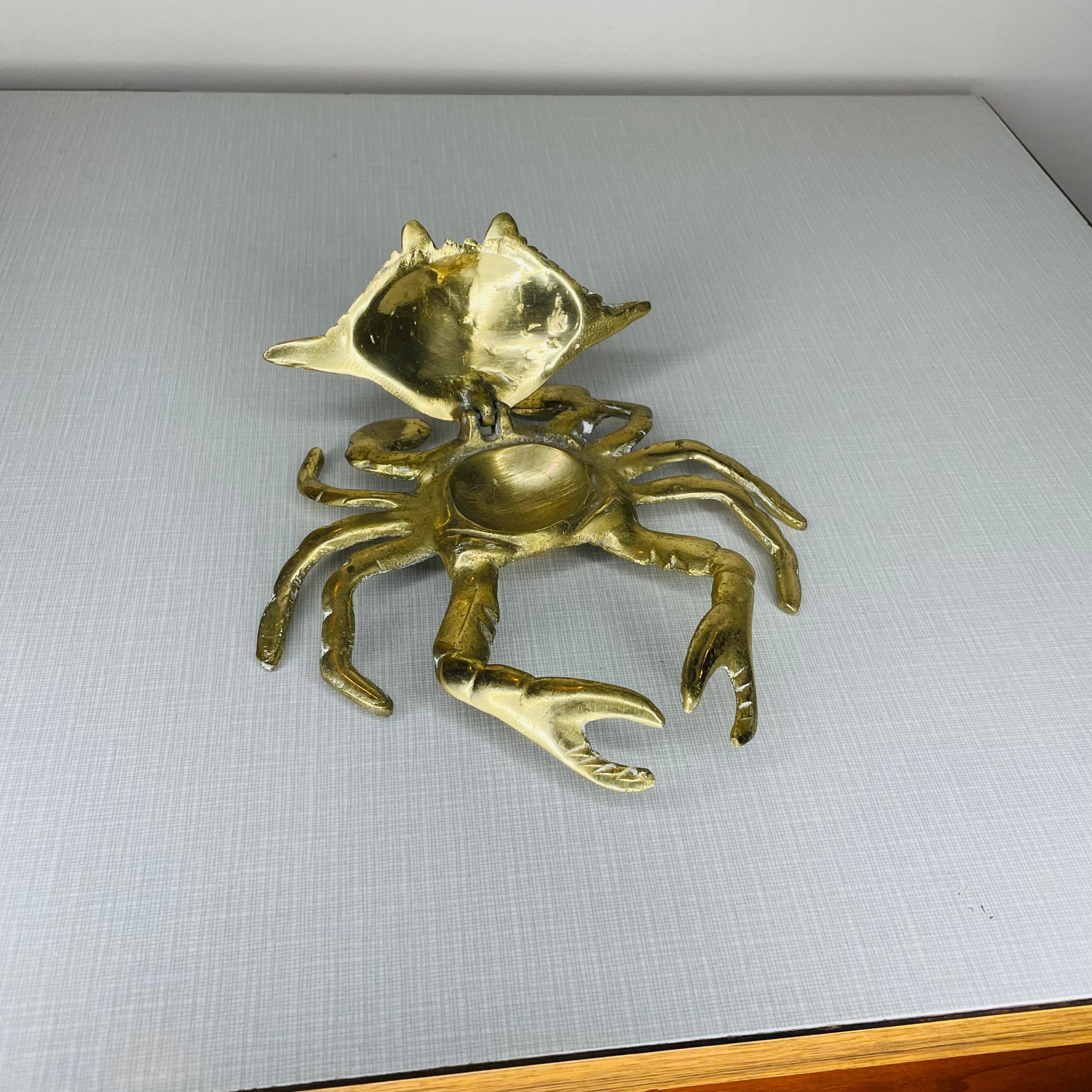 Polished brass crab figurine with attached lid. This could be used as an ashtray or could hold a few rings. There is not much storage space under the lid. The claws are stationary.