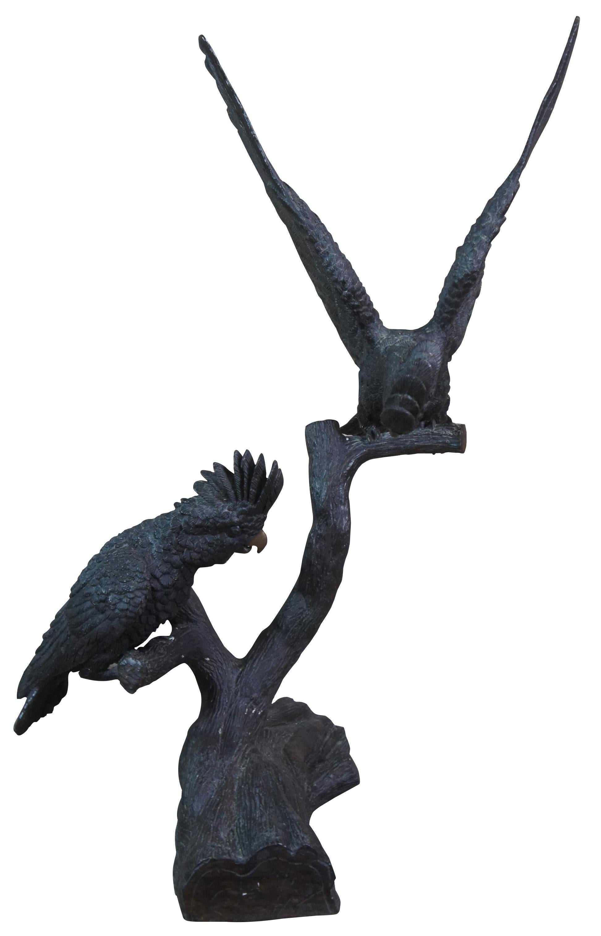 Mid 20th century French bronze cockatoos / parrots or birds. This life size art sculpture features a mated pair perched on a tree branch or log with realistic feathers, beaks and eyes. Made from the 