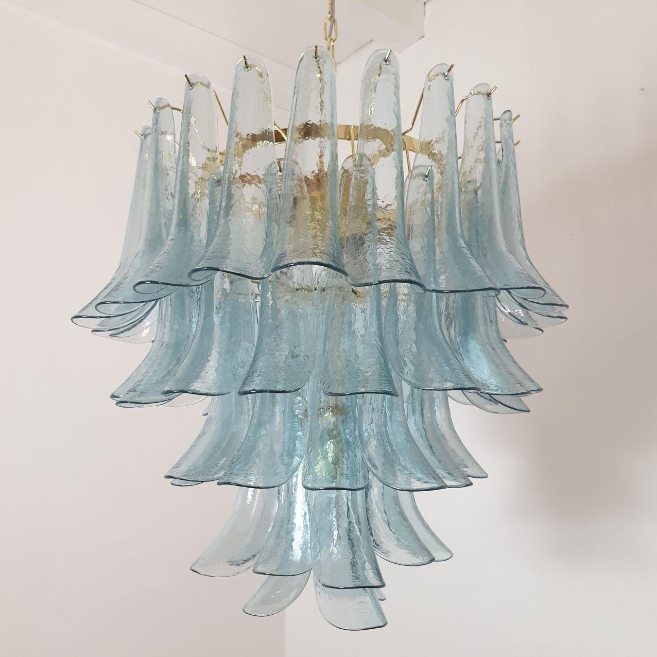 Mid century modern five-tier light blue Murano glass chandelier, by Mazzega, Italy, 1980s.
The light blue Murano glass chandelier is made of delicate handmade petal glasses, and a gold plated frame.
The Murano glass chandelier has seven lights, and