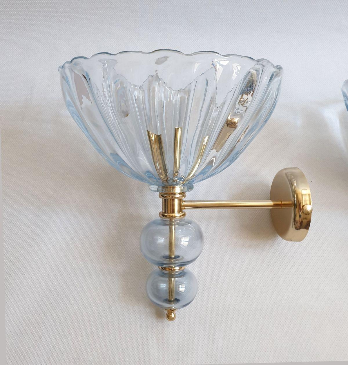 Pair of large handblown Murano glass wall sconces, Mid-Century Modern, attributed to Barovier & Toso, Italy 1970s.
The sconces are made of a very light blue thick Murano glass and polished brass mounts.
The vintage sconces have 1 light each and