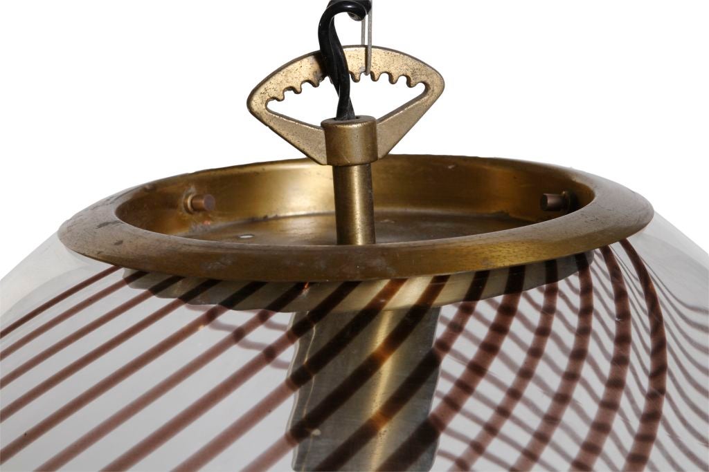 Groovy Mid-Century Modern brass and glass globe light fixture with a swirling design. Of Italian origin and purchased in Argentina.

Needs to be re-wired.