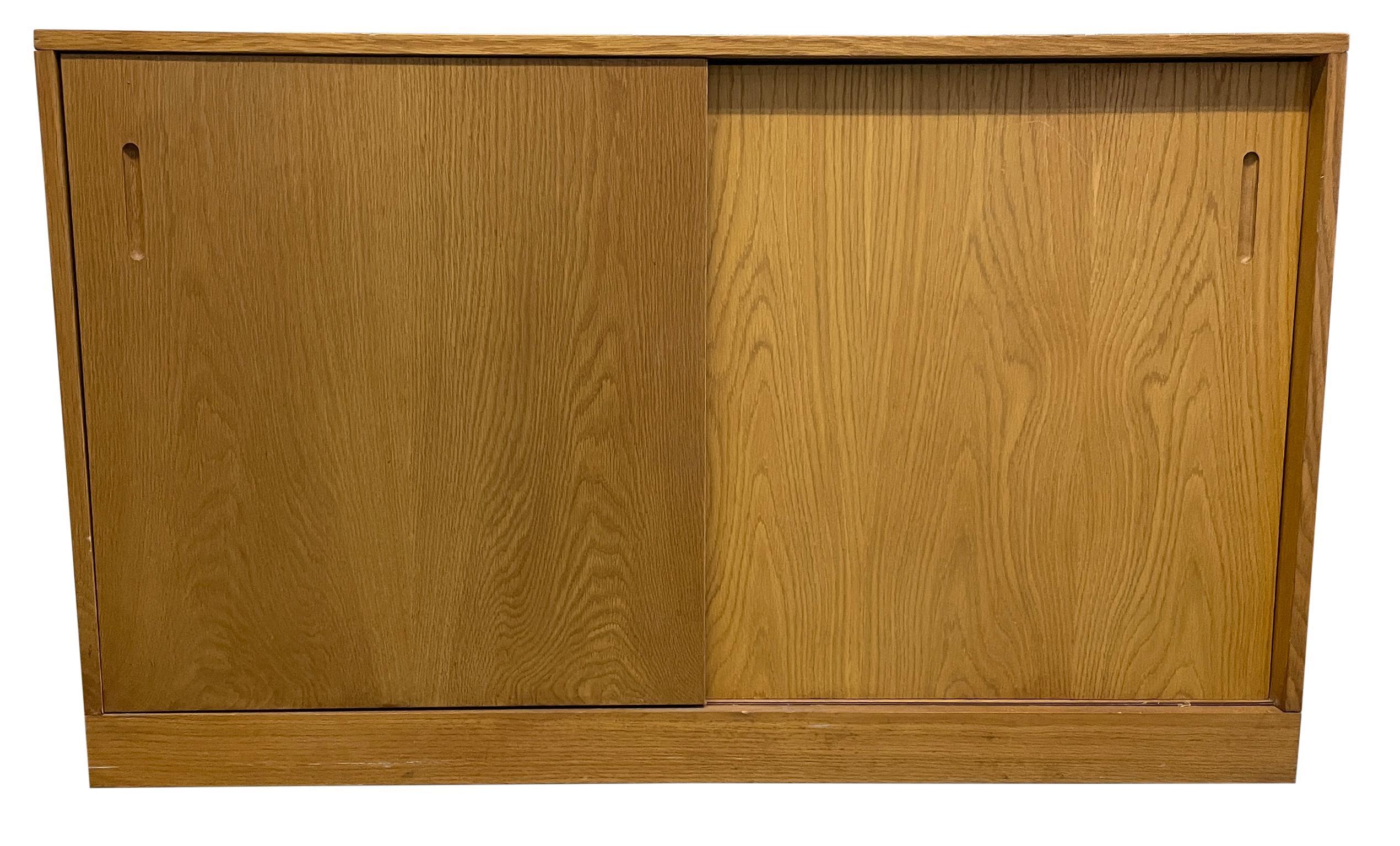 Credenza moderna danese di metà secolo in rovere chiaro con libreria a 6 ripiani regolabili. L'armadio inferiore è dotato di 2 ante scorrevoli con 1 lungo ripiano regolabile all'interno. La libreria superiore è rimovibile e dispone di 6 ripiani