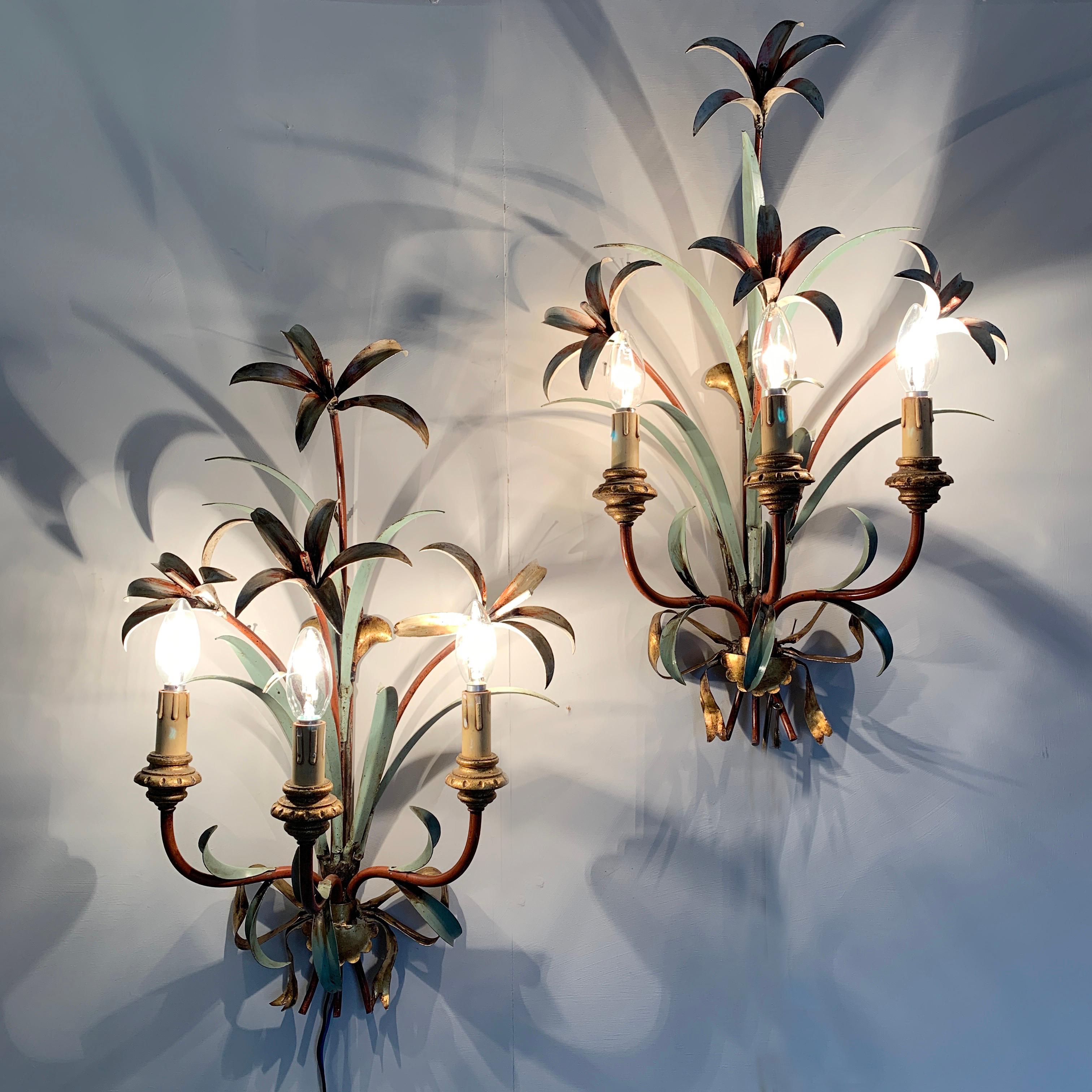 Midcentury lily flower tole wall lights
1950s, Italian
These large wall sconces made from hand formed metal leaves and flowers are stunning. There are 4 large lily heads and multiple lean green leaves surrounding them
Three curved red arms hold