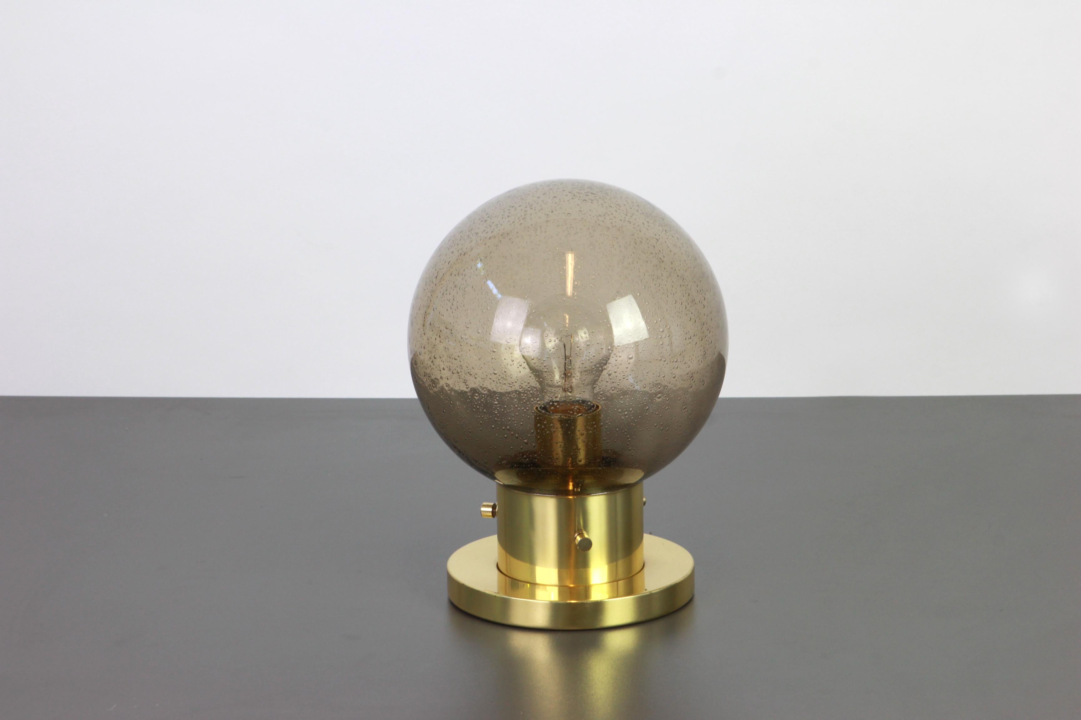 Stunning midcentury ceiling or wall lamp in Ball shape, by
Glashütte Limburg, Germany, 1970s.
Made of smocked glass and brass.
Sockets: It needs 1 x E27 standard bulb and function on voltage from 110 till 240 volts.

Measures: Height ca. 28 cm