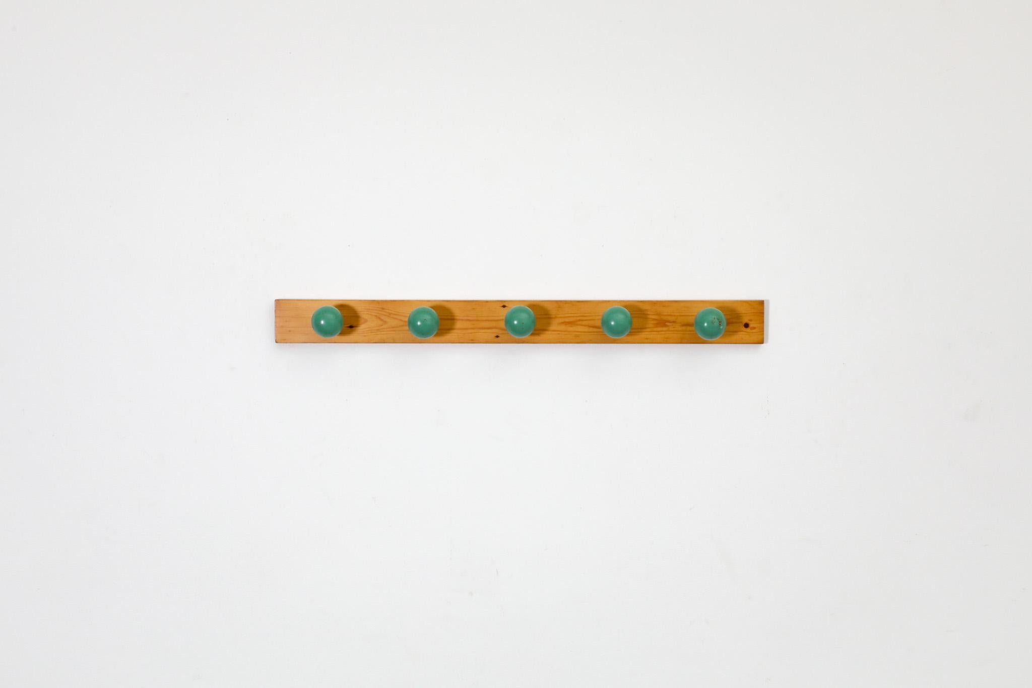 This fun 1980's Mid-Century Post Modern wall mount coat rack has a linear pine back and spotted with 5 large green lacquered wood ball shaped hooks for hanging all your favorite accessories. In original condition with wear consistent with age and