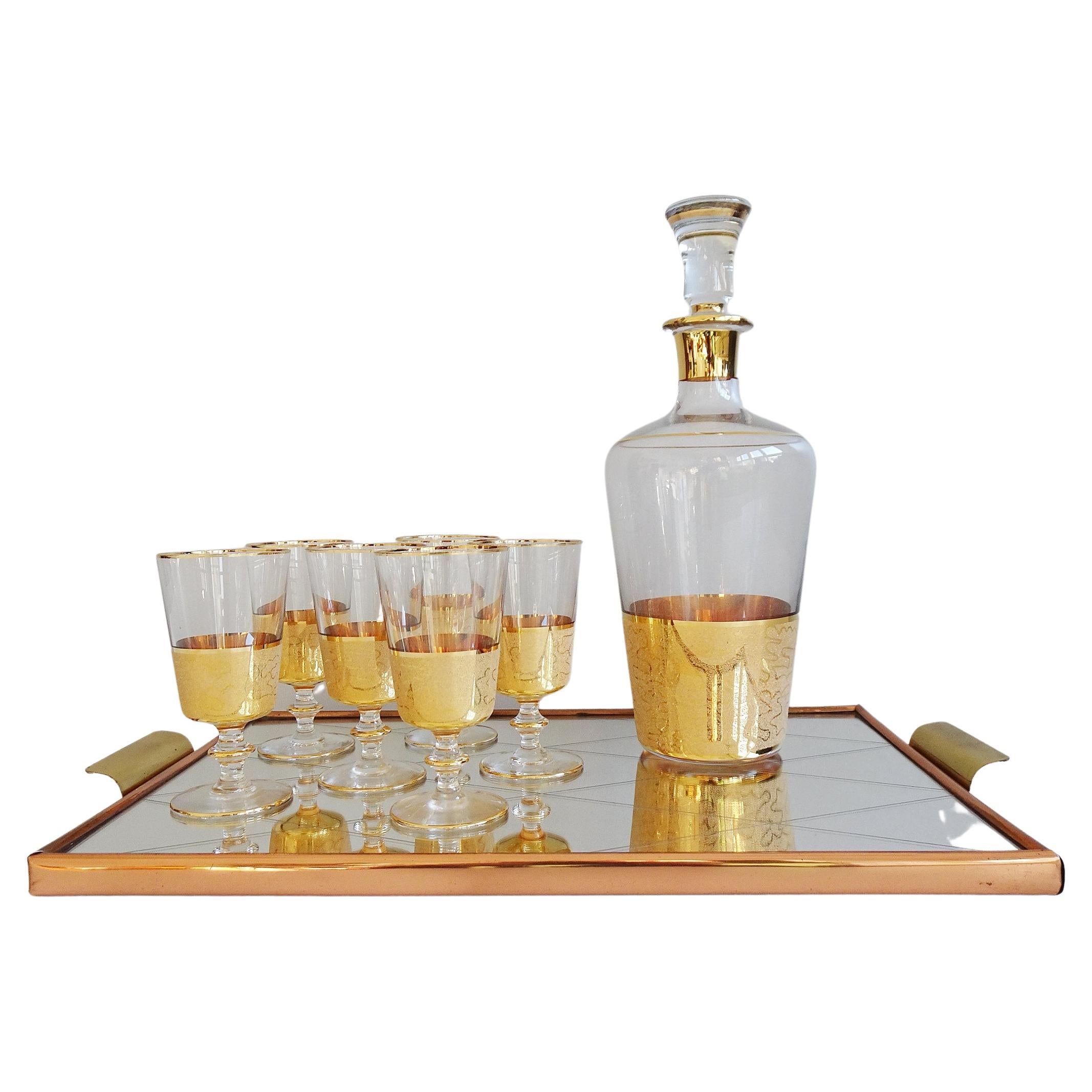 Stylish bar set consisting of a liqueur carafe with six glasses and a tray. A fancy and noble bar accessory from the mid century that convinces with color and design. A glass carafe with a cap and six liqueur glasses, with a gold decor typical of