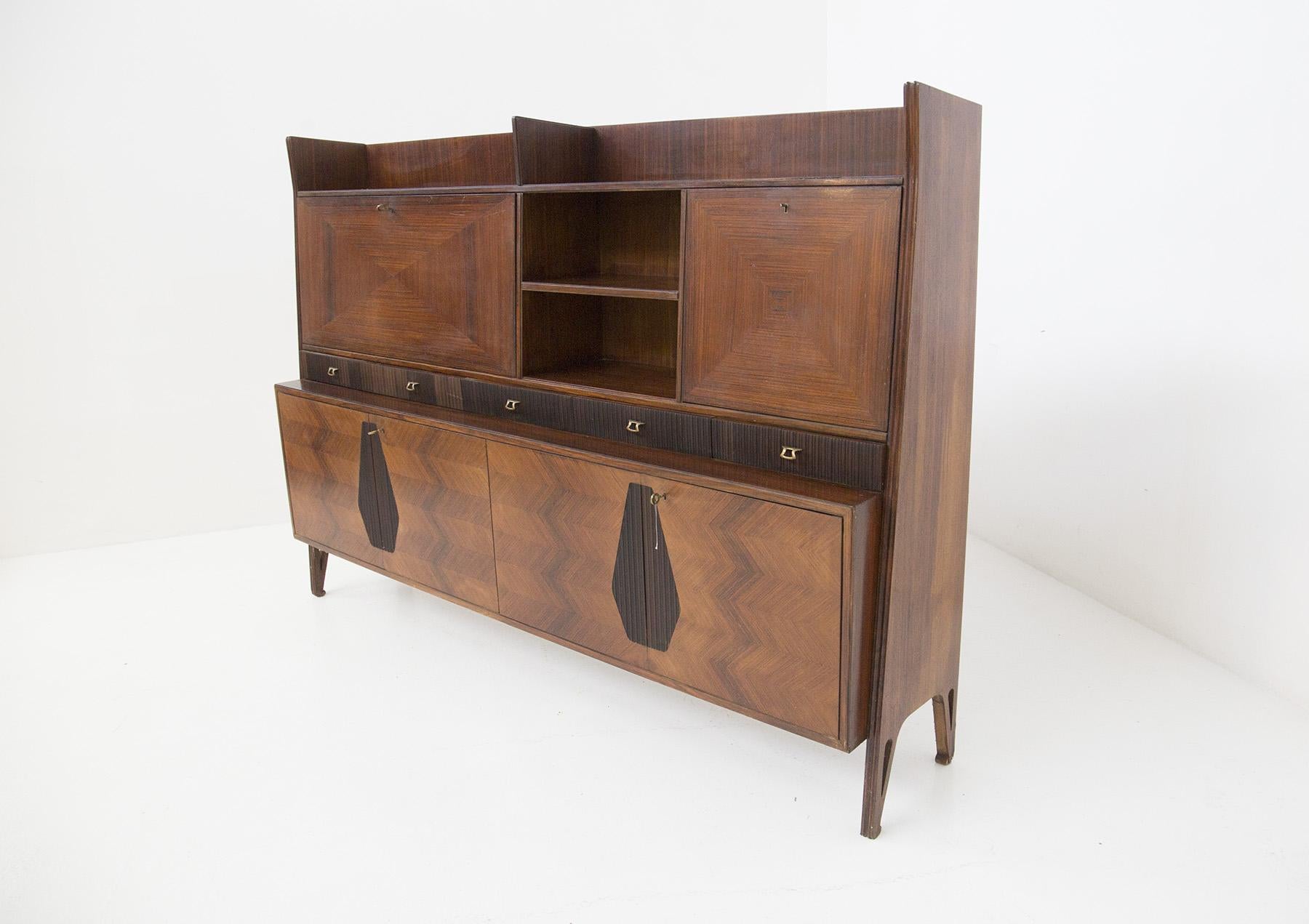 Beautiful, high-quality living room furniture produced by Permanente Mobili of Cantù. The 1950s cabinet features excellent fine woodwork. Elegant grissinato inserts and extraordinary geometric shapes carved from the wood grain. The handles and keys