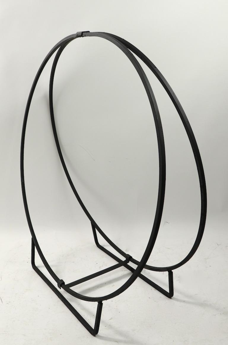 Architectural circular log holder of solid stock wrought iron. Freestanding, having two large (39.25 inch diameter) rings, which hold the logs in place. Sturdy and strong construction, clean and ready to use.