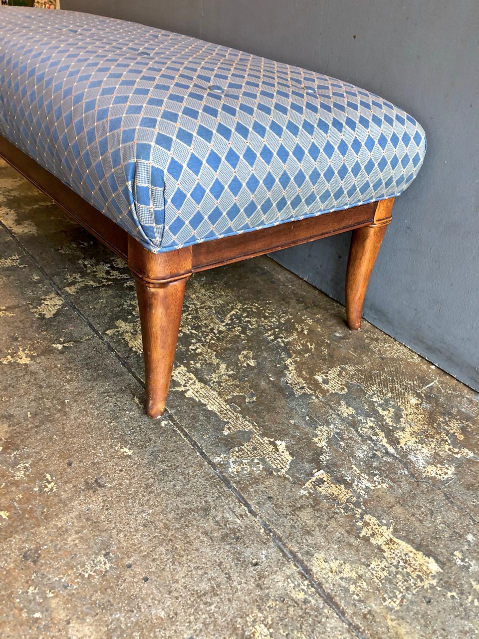 This is a wonderful saber-legged bench that dates to the mid-20th century. The bench is in overall very good condition with vintage upholstery. This is the perfect end-of-the-bed detail.