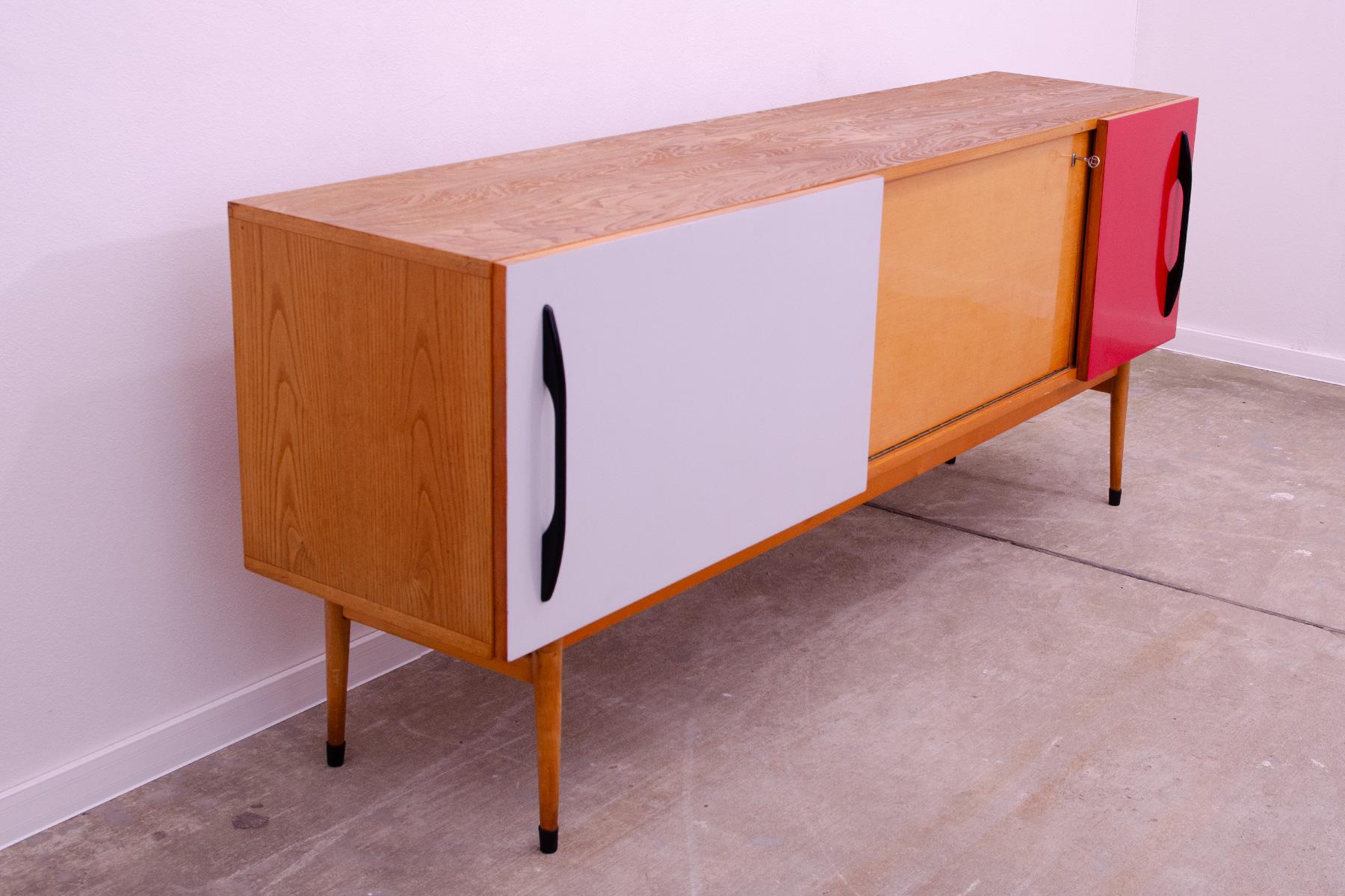 This Vintage long sideboard was made in the former Czechoslovakia in the style 1960´s.

It´s made of beechwood, ash and plywood.

It has a colored slidding doors.

It´s in very good Vintage condition, shows normal signs of age and use.

Height: 77