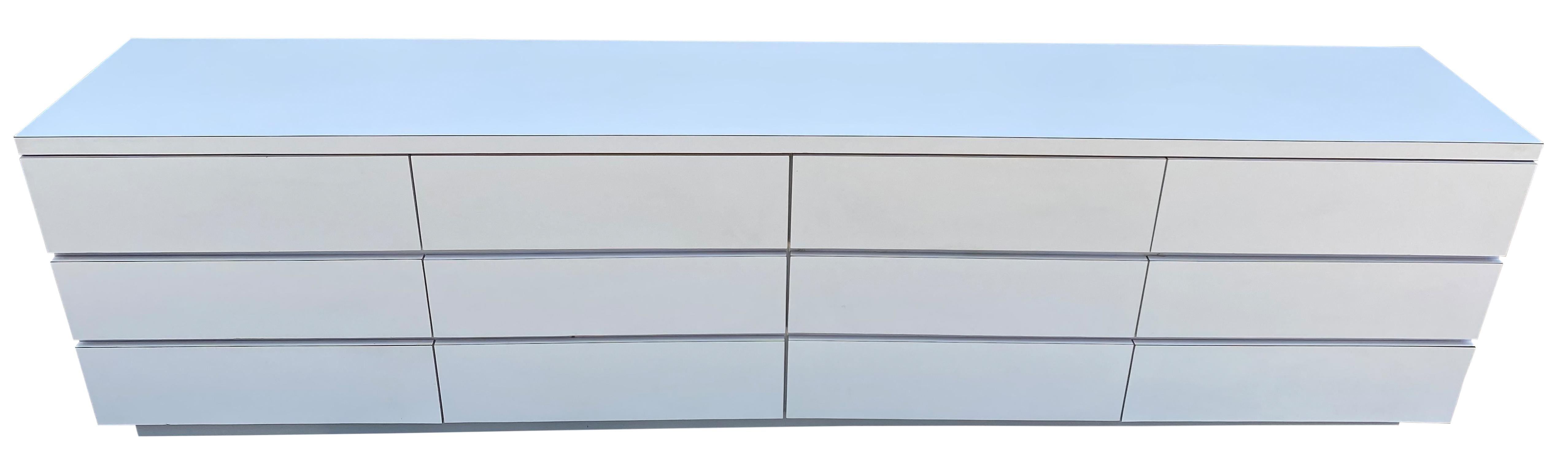 Very long matte white Formica laminate plywood custom 12-drawer dresser credenza, circa 1980s custom made to fit in a bedroom. Comes apart in 4 sections easy to move and assemble and set up as a floor dresser of mount on a wall as a floating