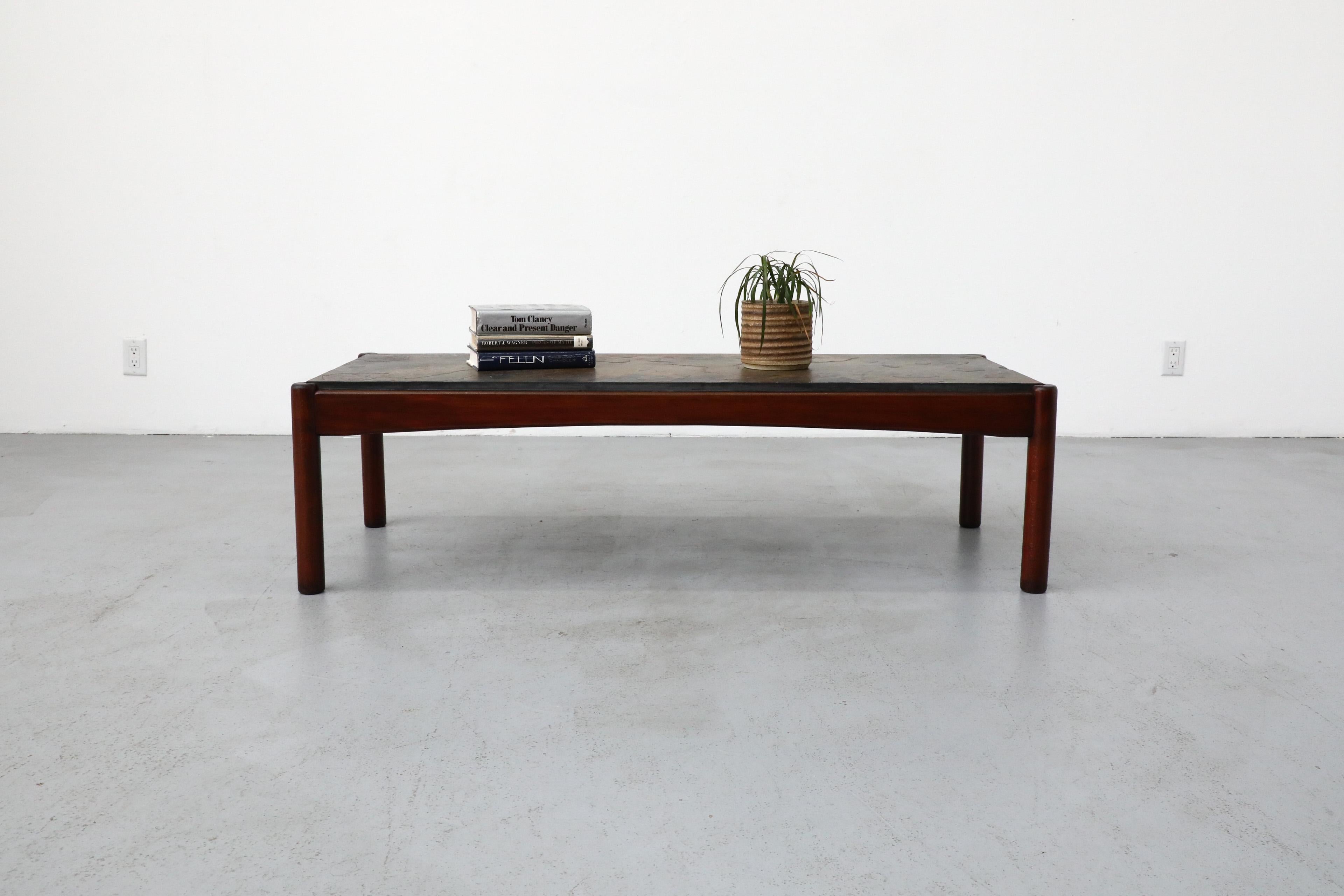 Table basse rectangulaire du milieu du siècle avec un superbe plateau en pierre et un cadre en bois de style danois. Le cadre en bois est teinté en cerisier foncé. En état original avec une usure visible correspondant à son âge et à son utilisation.